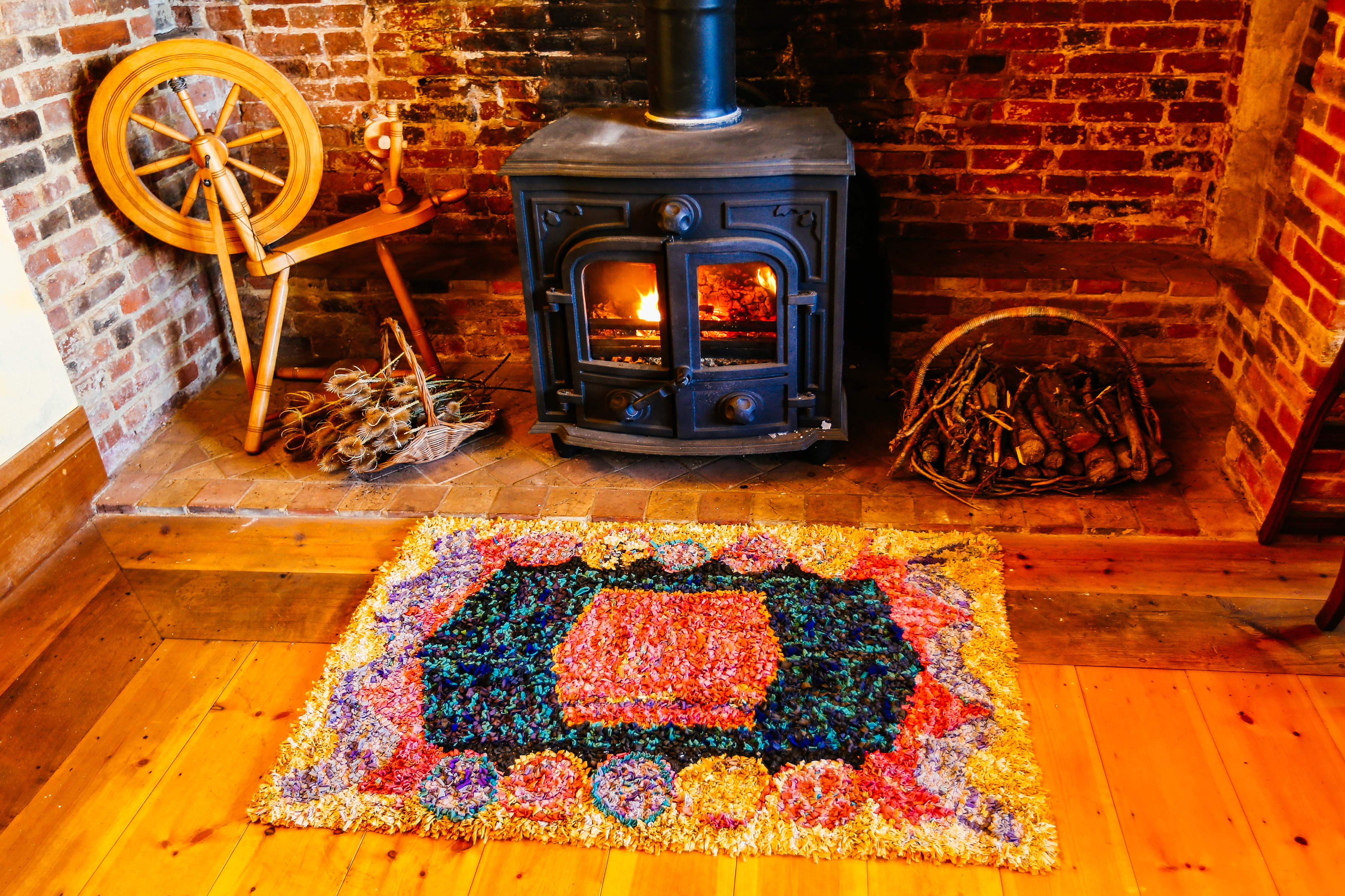 Multicoloured upcycled handmade Winter rag rug in front of log burner 