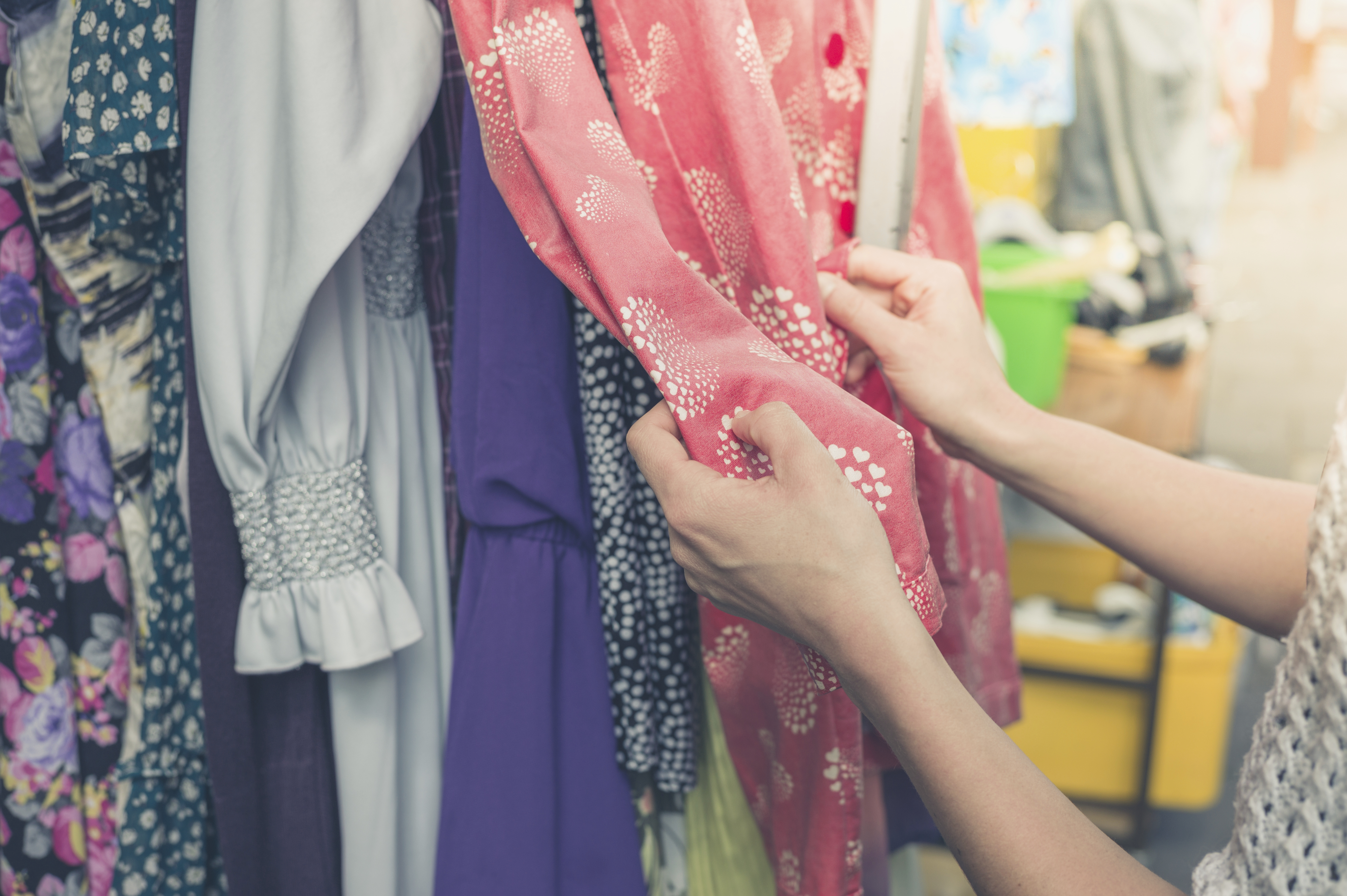 A woman browsing clothing in a charity shop