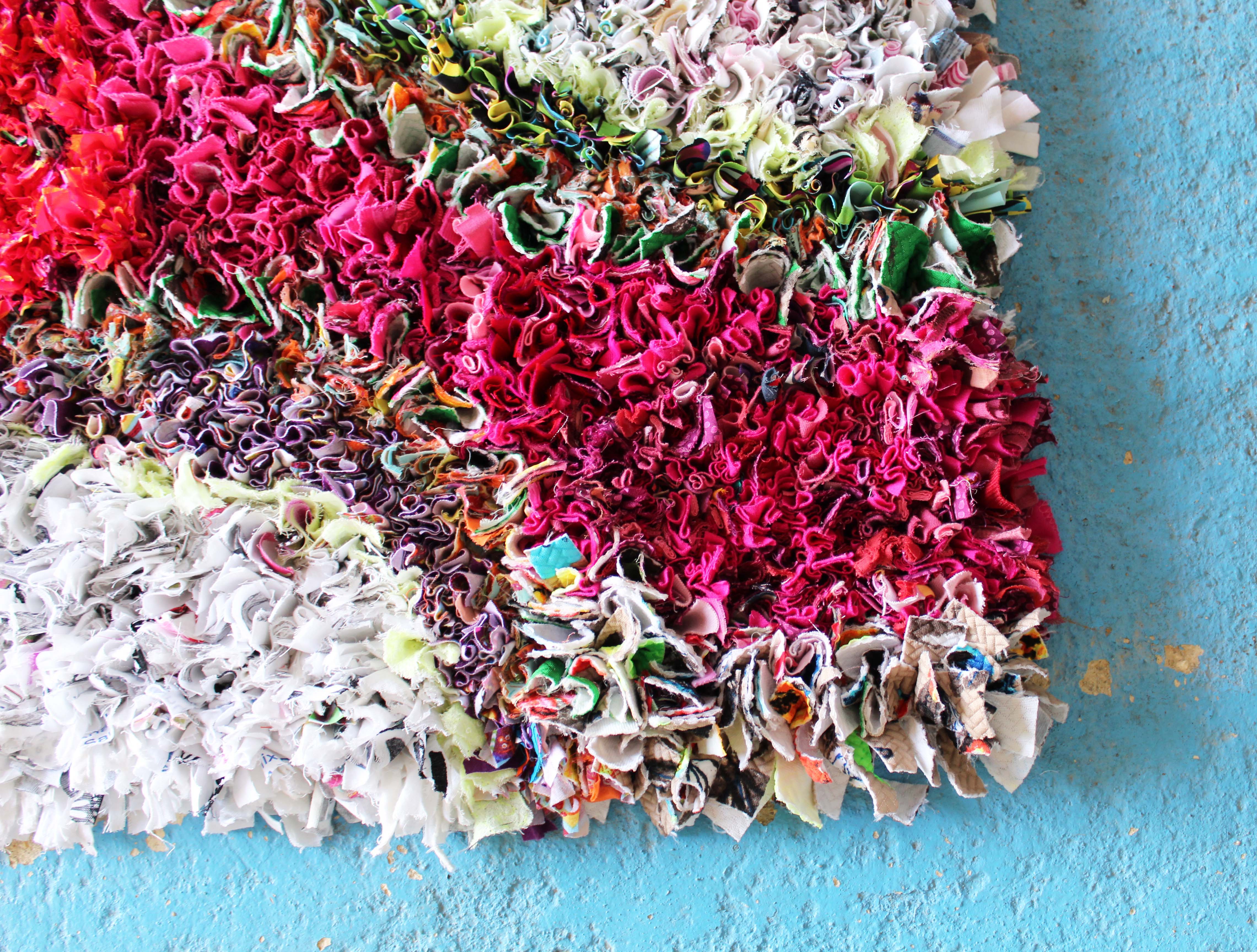 Close up photo of pink shaggy rag rugging on the corner of a handmade rag rug