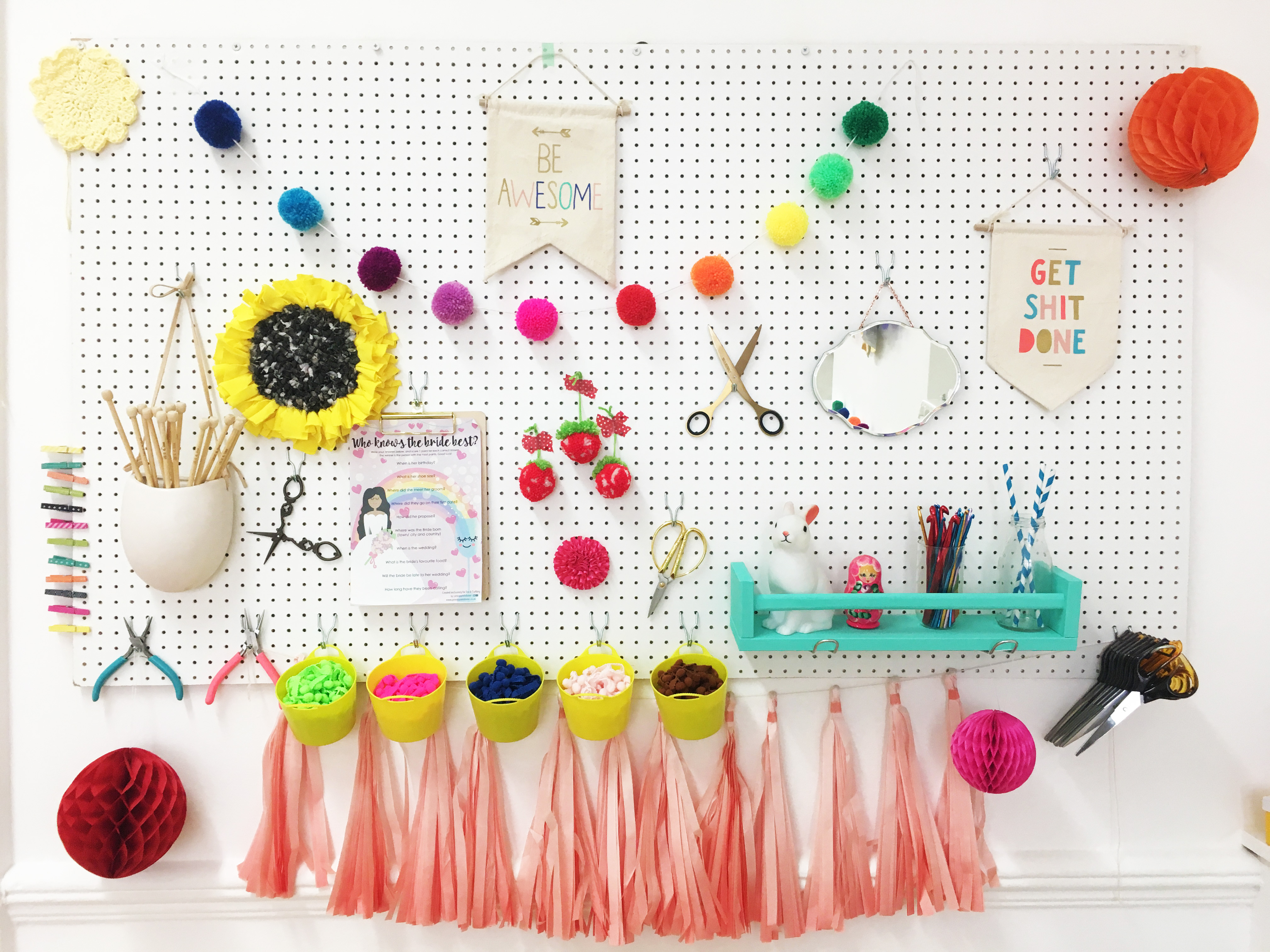 A colourful pegboard with pom poms, streamers and craft tools at Tea and Crafting Covent Garden