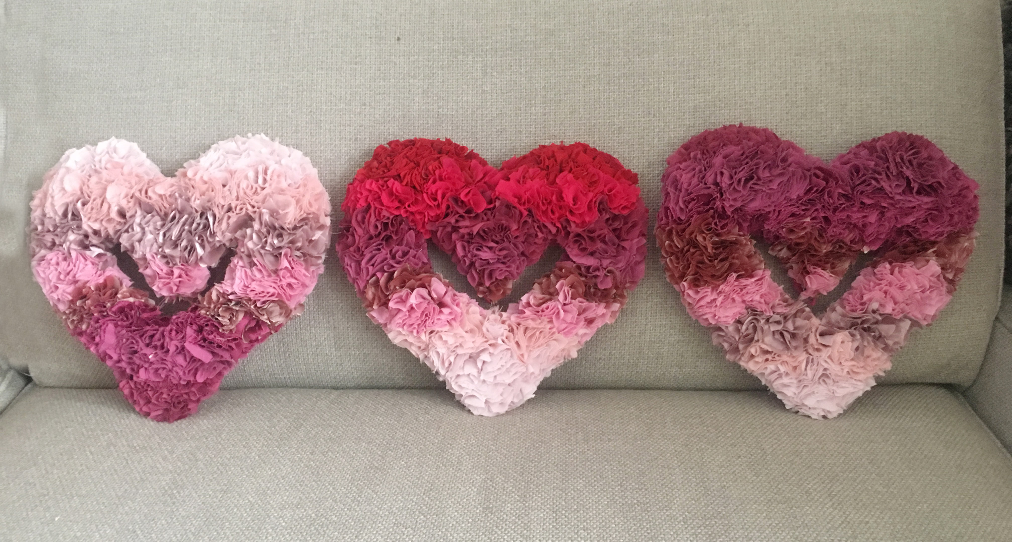 Gradiated Pink and Red Rag Rug Heart Wreaths on Grey Sofa 