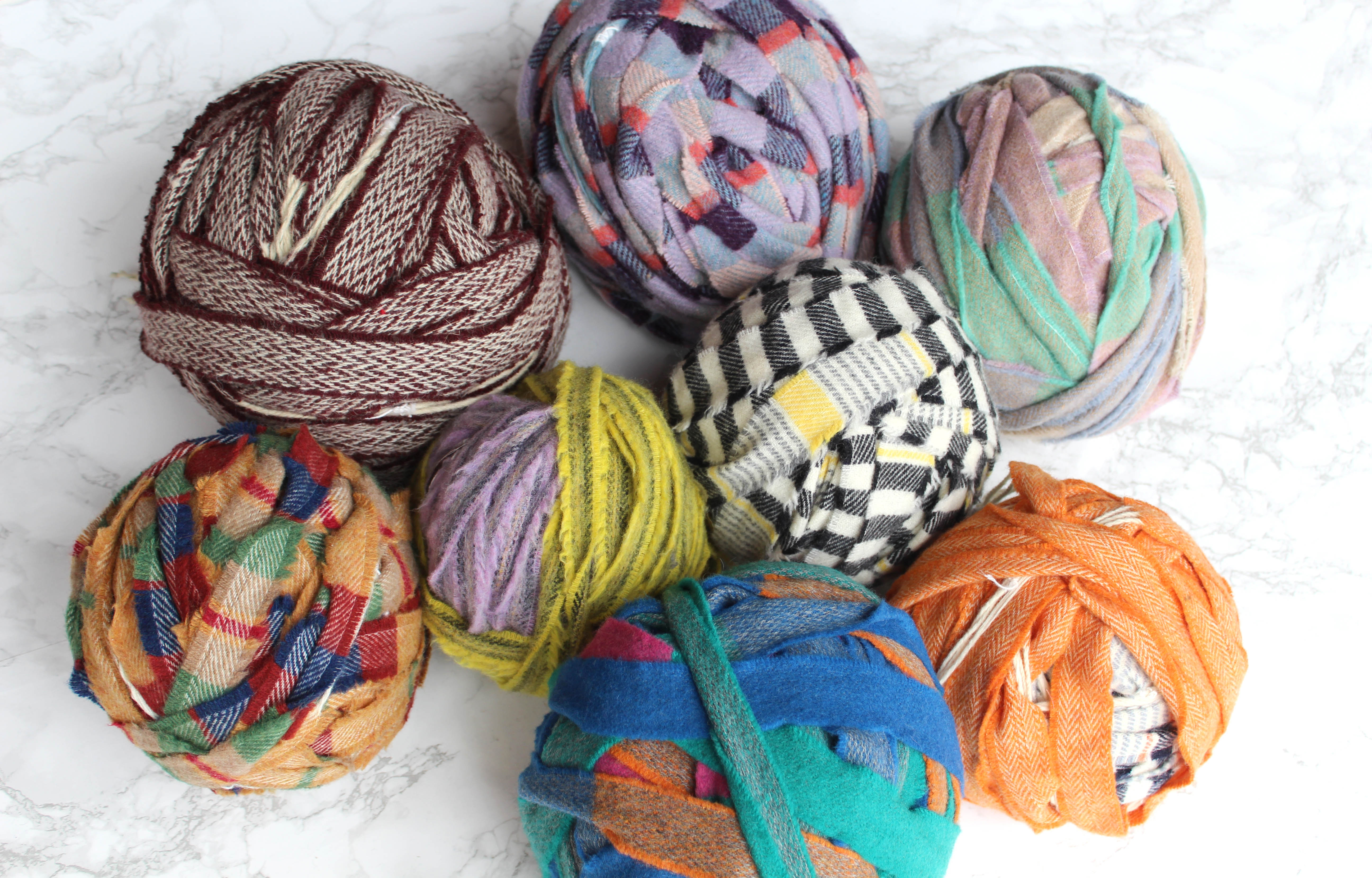 Balls of multicoloured and plaid blanket yarn for craft