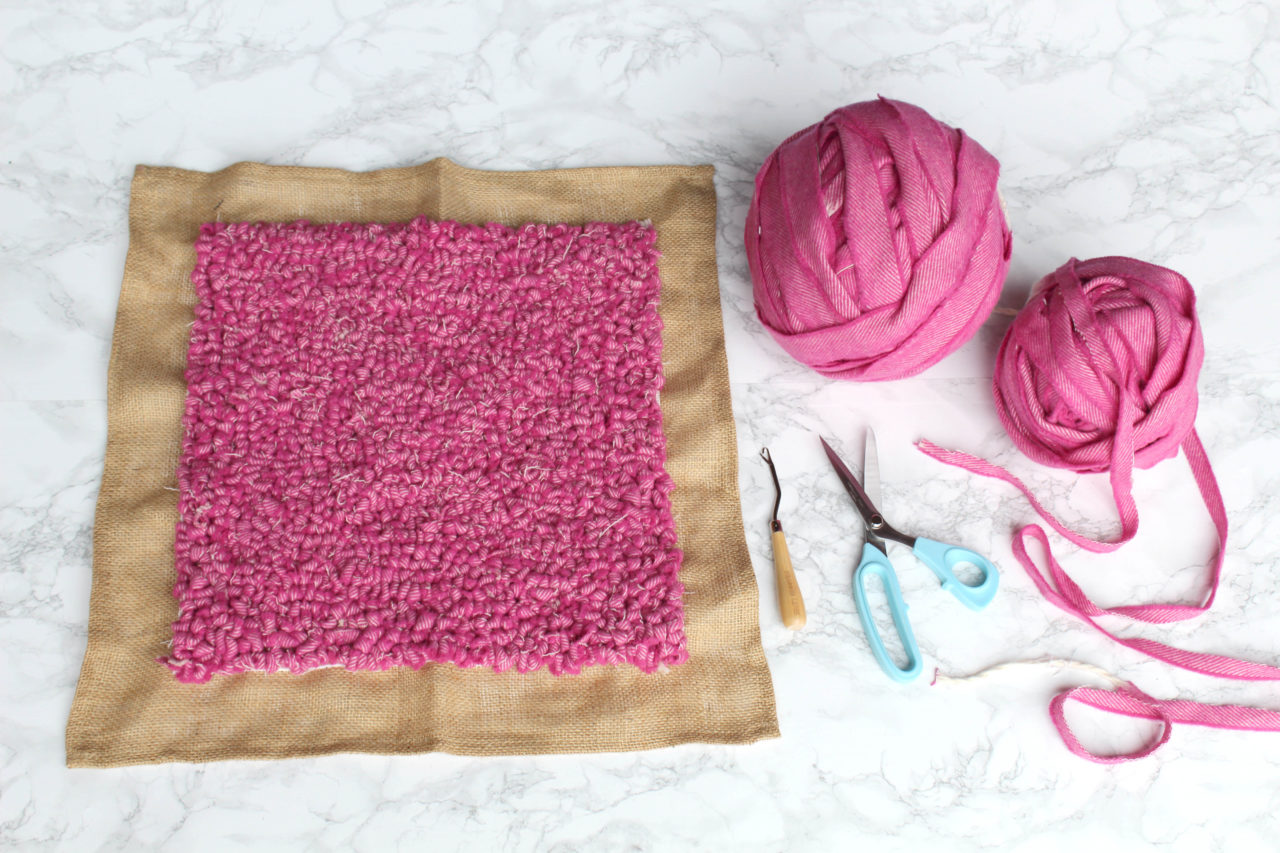 A cushion cover made entirely using pink blanket yarn and rag rugged in the loopy technique