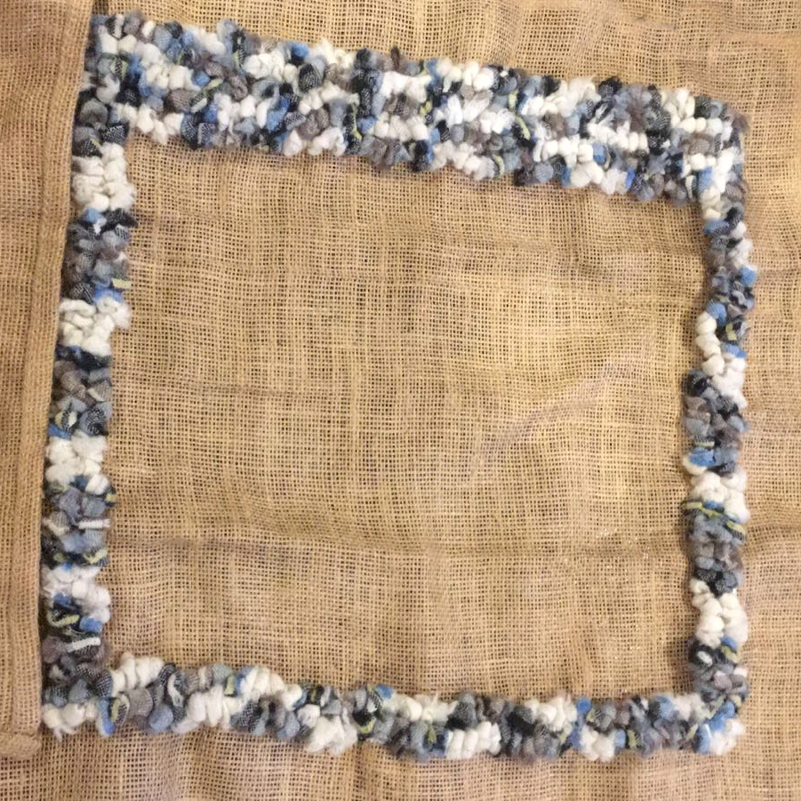 Blue and white blanket yarn rag rugged into a cushion cover.