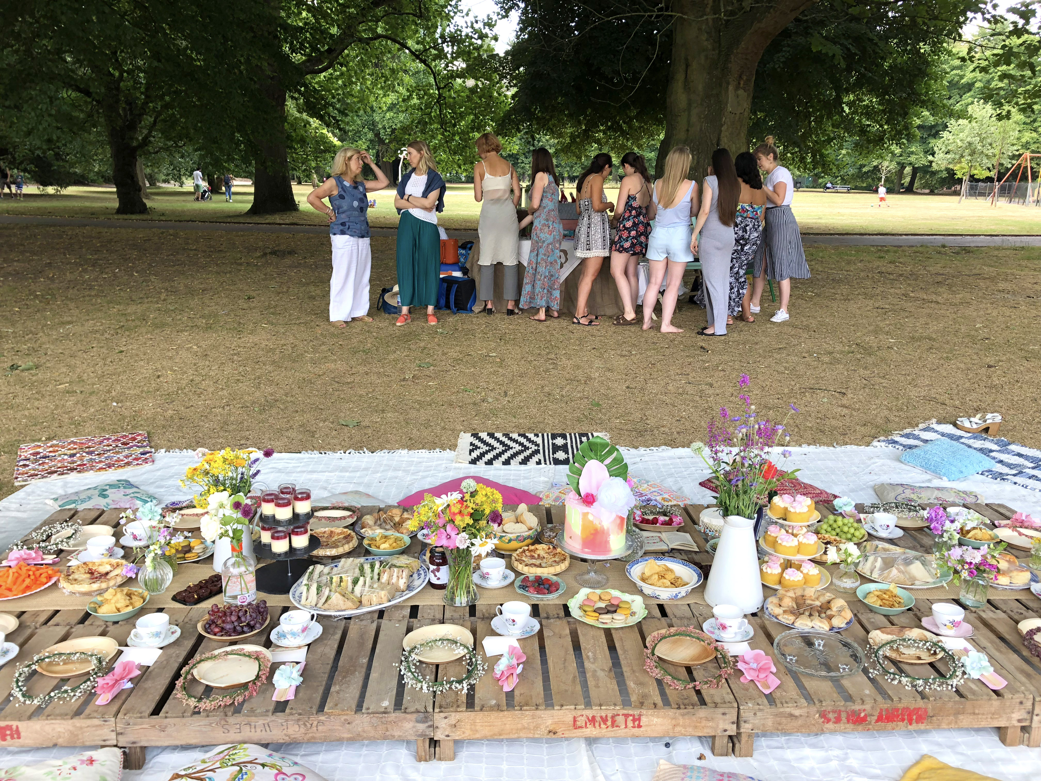 Cheap hen do picnic in the park with flowers and bohemian decorations