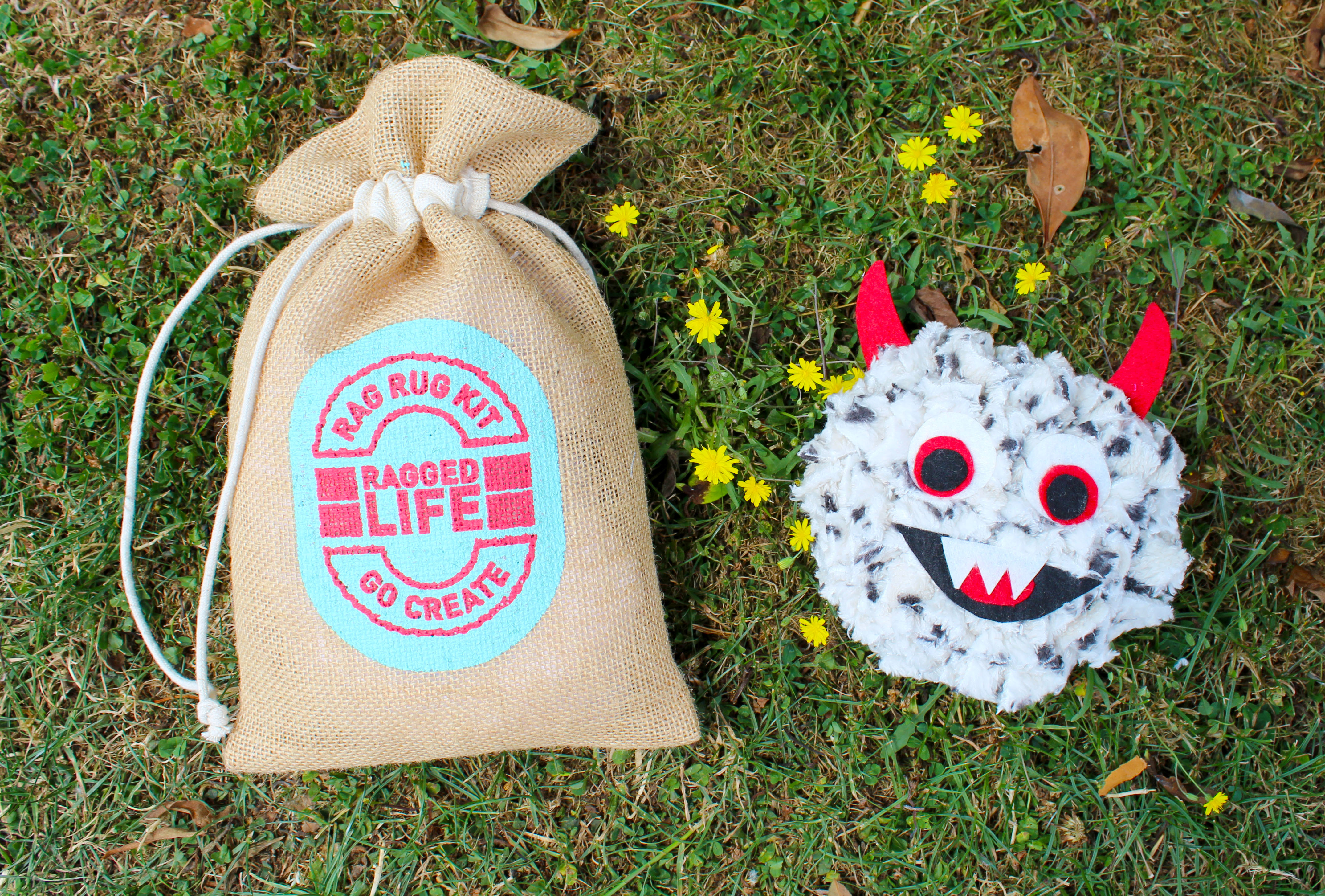 Ragged Life Rag-a-Monster Rag Rug Kit bag and rag-a-monster toy on grass