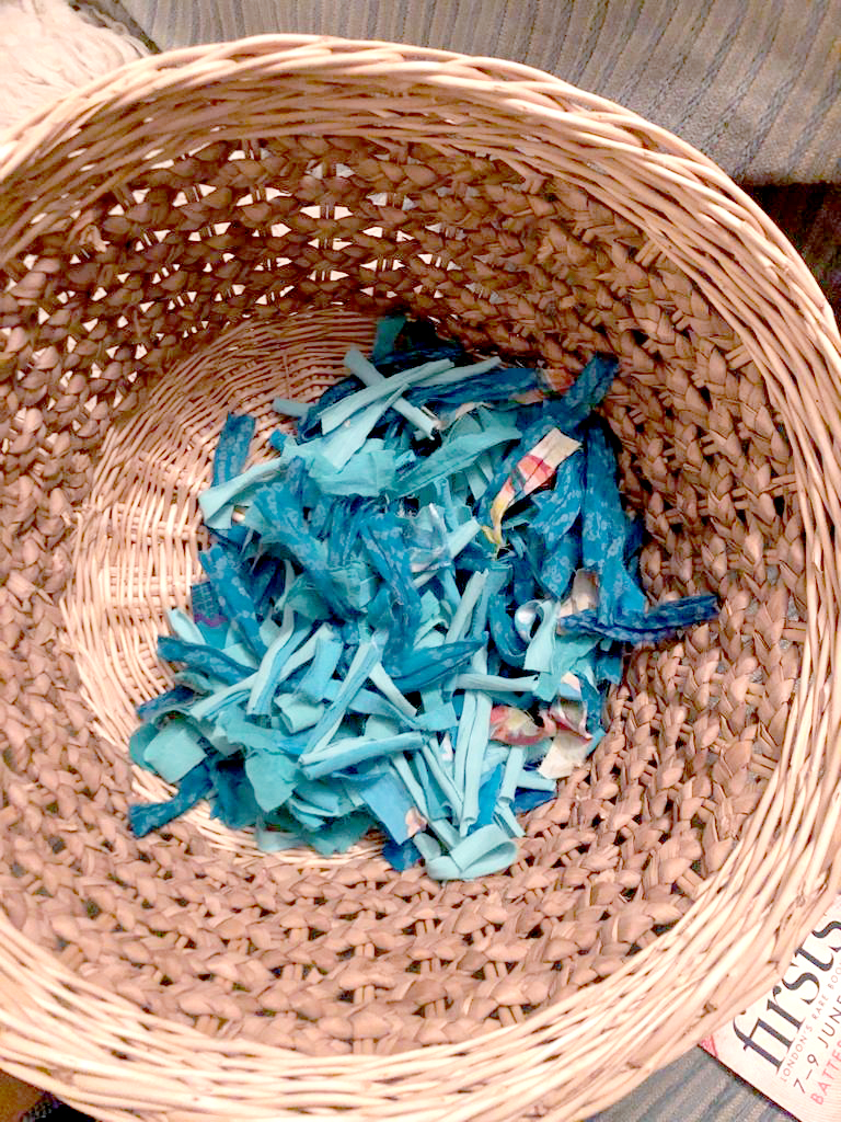 Fabric scraps in a basket for rag rug making