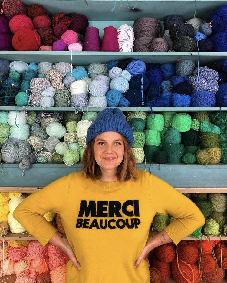 Trish Andersen with a wall of wool