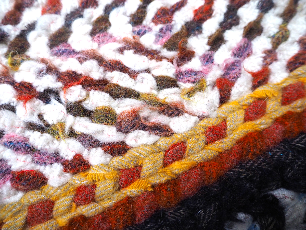 Close up detail of twined rug in scarf offcuts