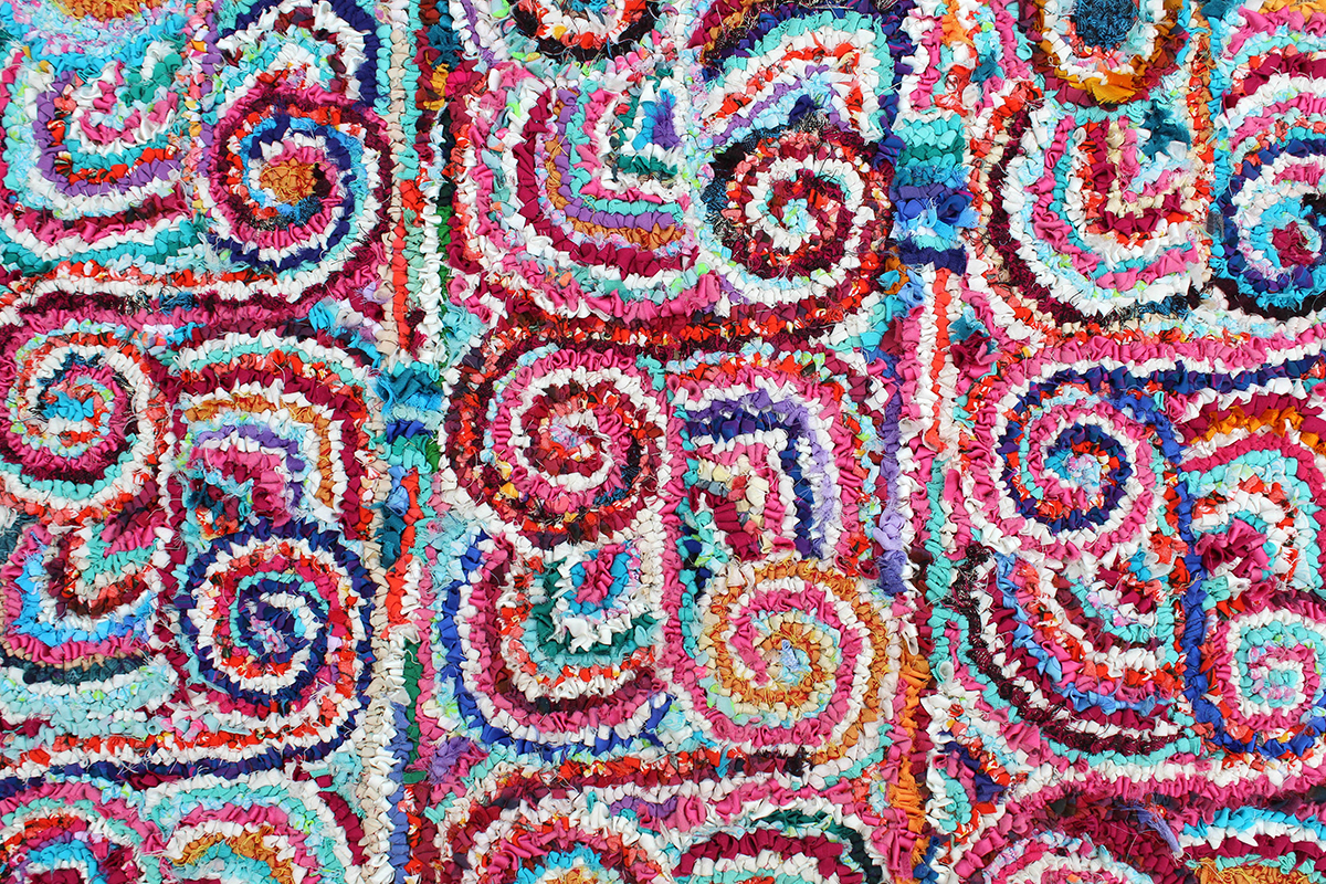 Celtic shield inspired colourful rag rug in the hooked or loopy technique of rag rugging made by textile artist Victoria Jackson