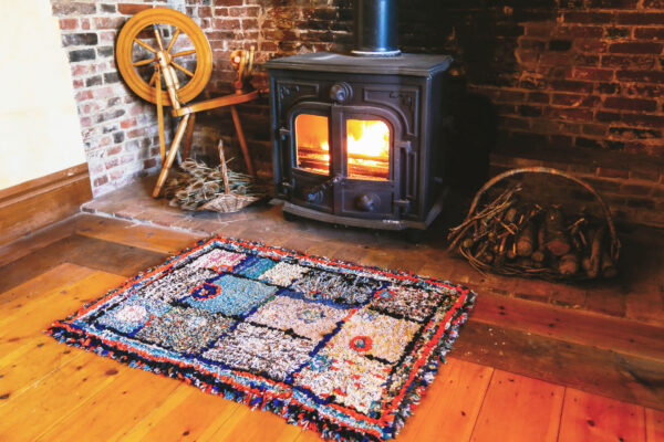 Old rustic rag rug in front of a log burner