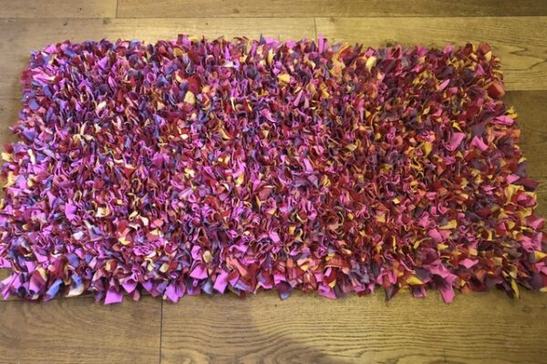 Pink shaggy proggy rag rug made using an old duvet cover