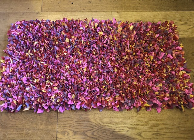 Pink shaggy proggy rag rug made using an old duvet cover