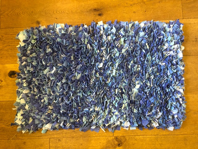 Blue shaggy rag rug on floor