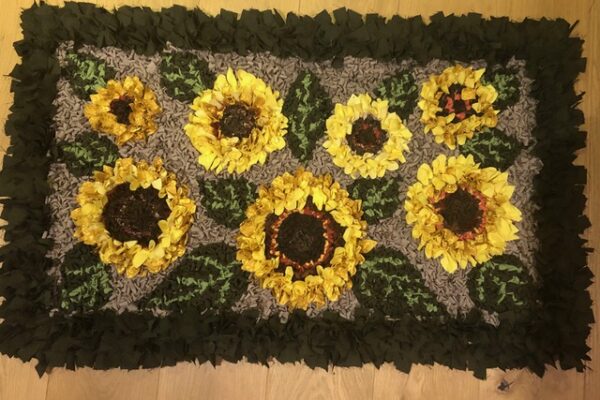 Handmade sunflower design rag rug with green leaves and dark border