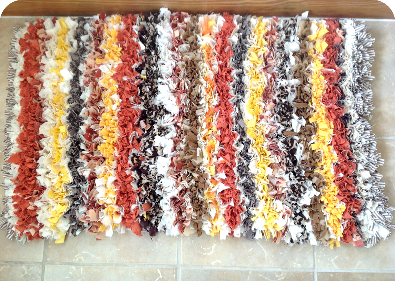 Brown, orange, yellow and warm coloured stripey rag rug made using old textiles. Made in the traditional proggy technique using a rag rug spring tool. 