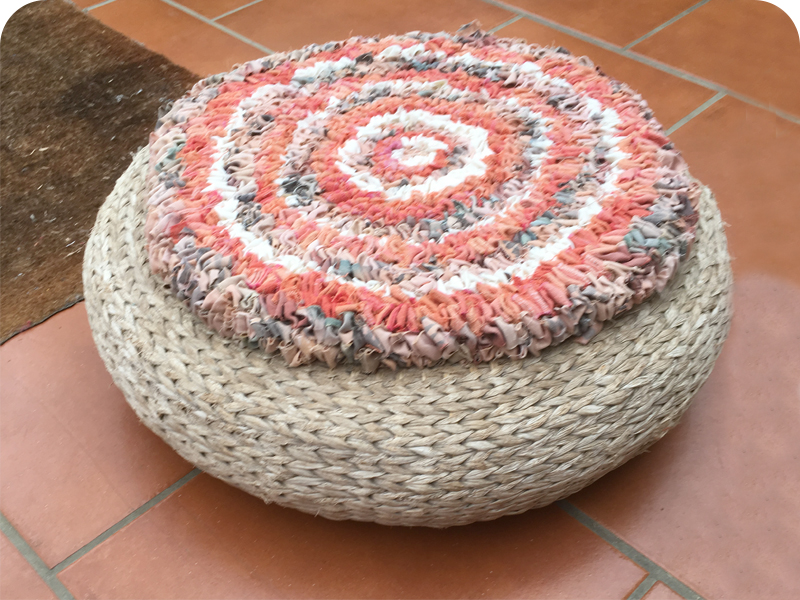 Loopy or hooky rag rug circular footstool in orange, cream and brown