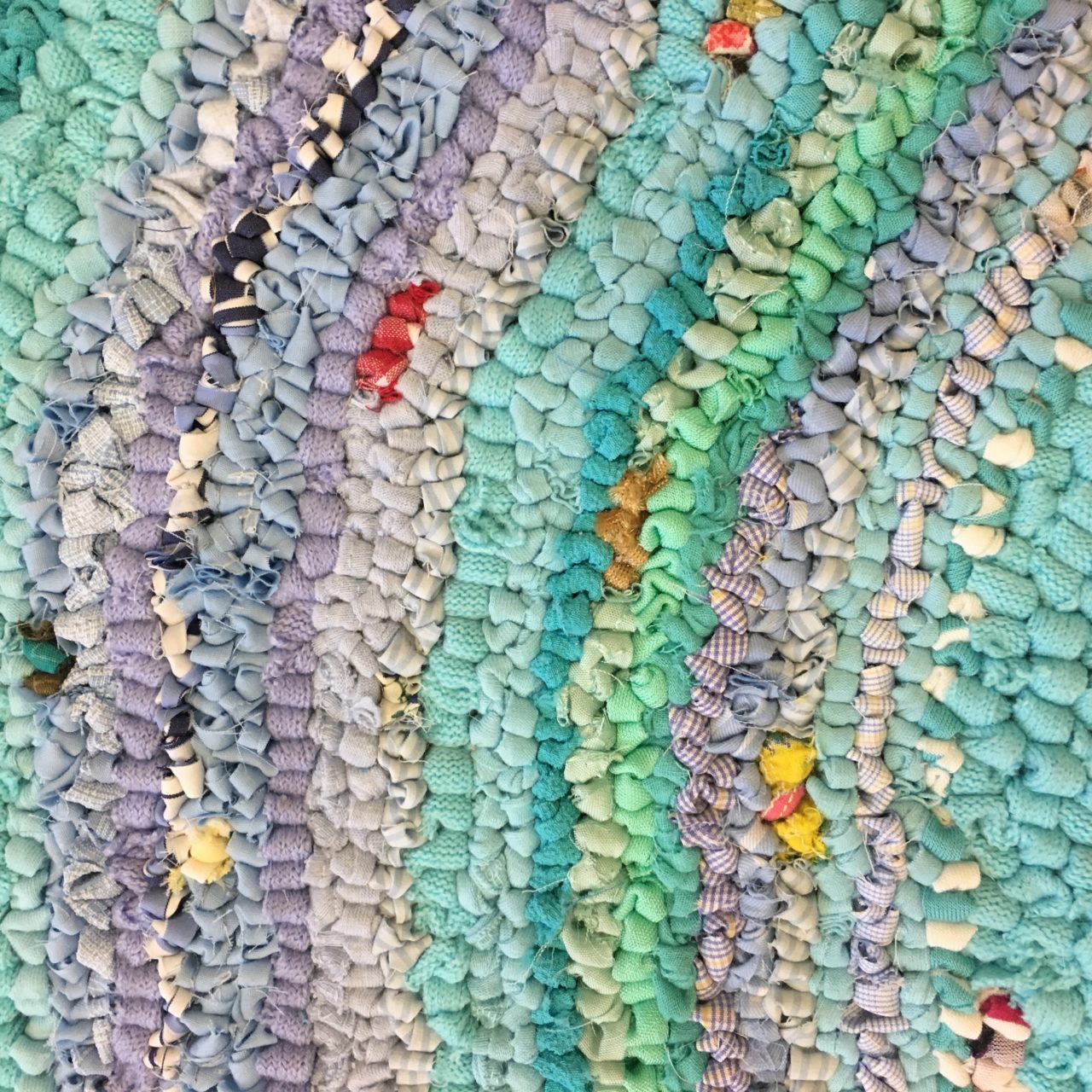 Stripes of blue hooky rag rugging in a rag rug wall hanging piece of art