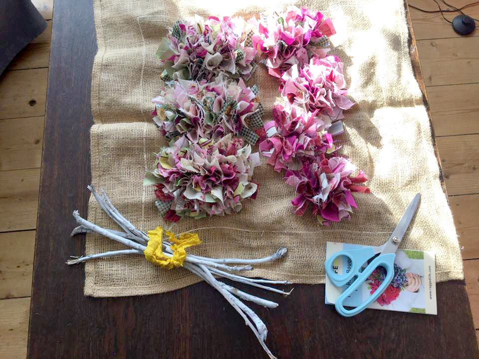 Unassembled rag rug bouquet kit with seven flowers and flower stems and ragged life rag rug scissors