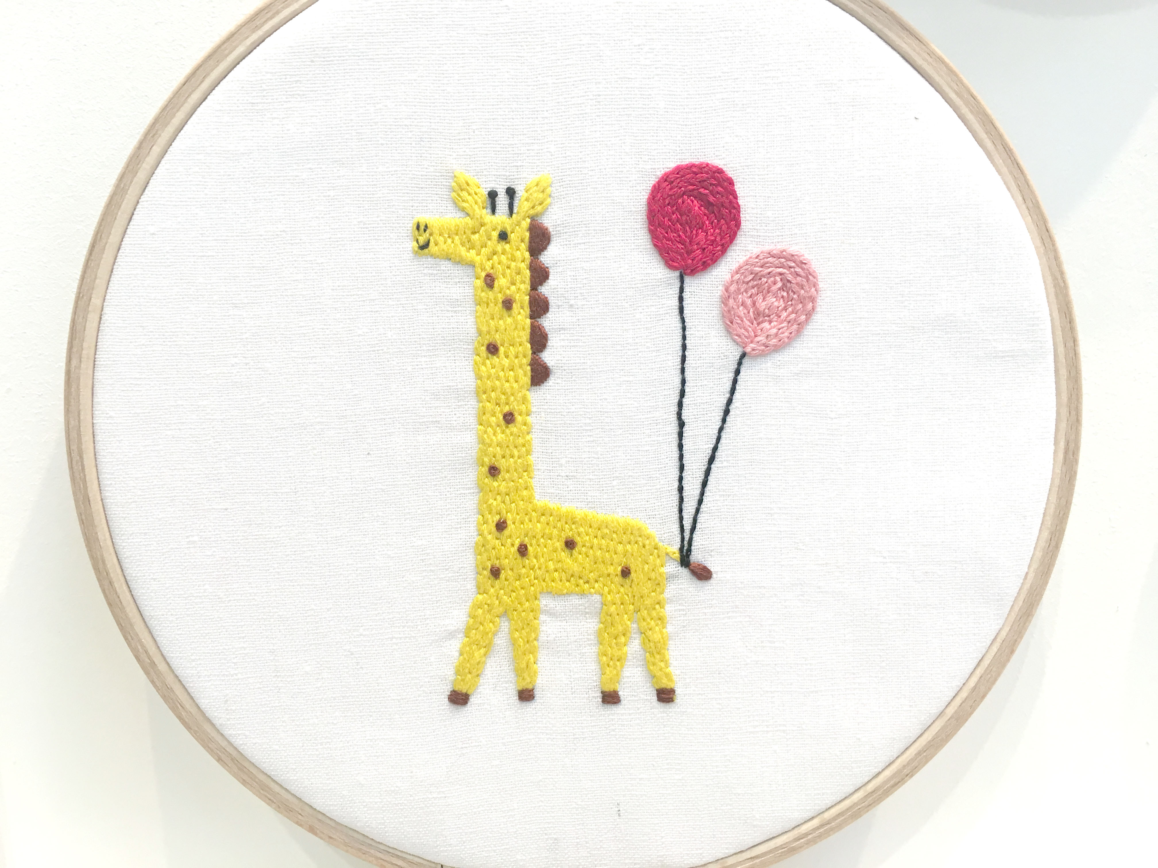 Yellow embroidered giraffe with balloons