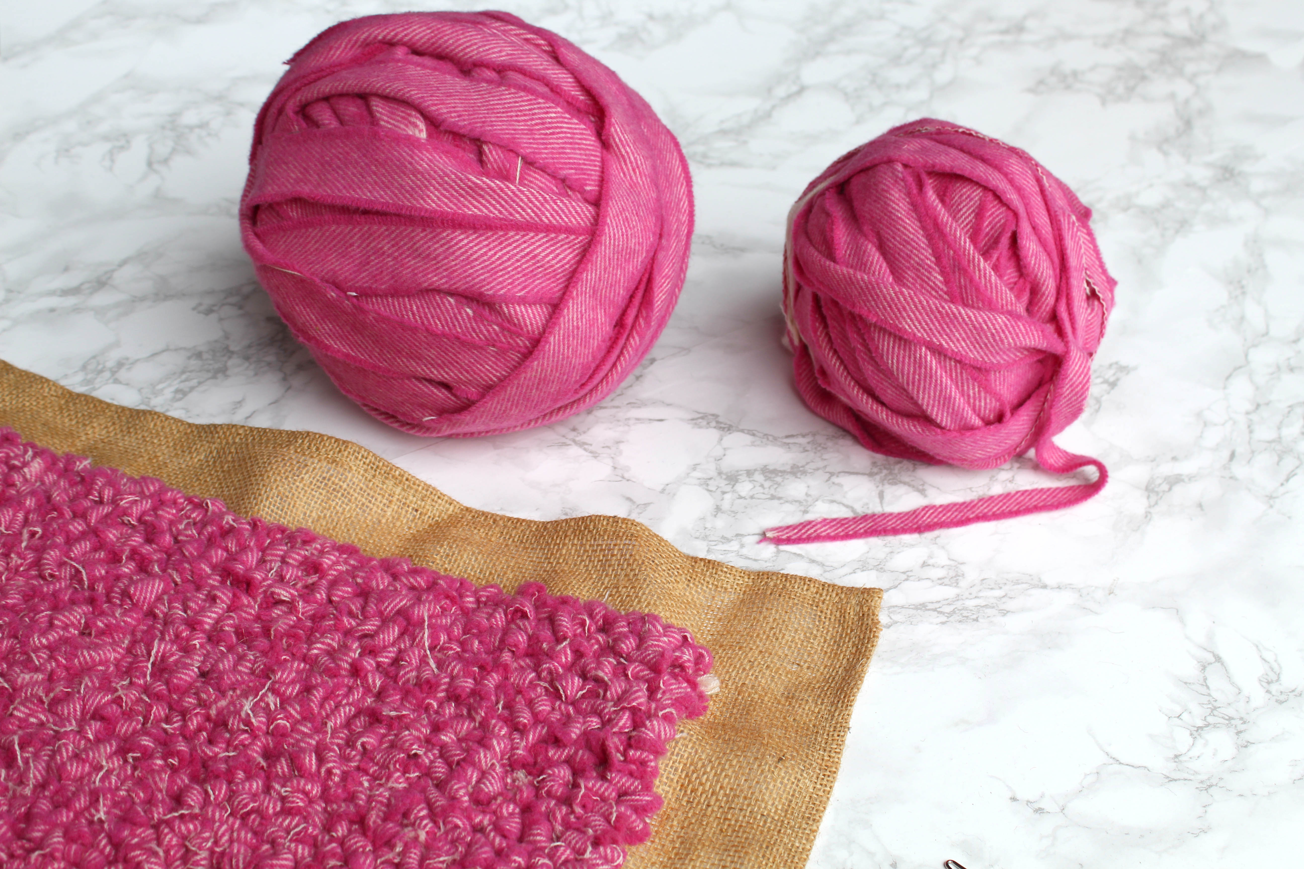 Balls of pink blanket yarn with pink rag rugging
