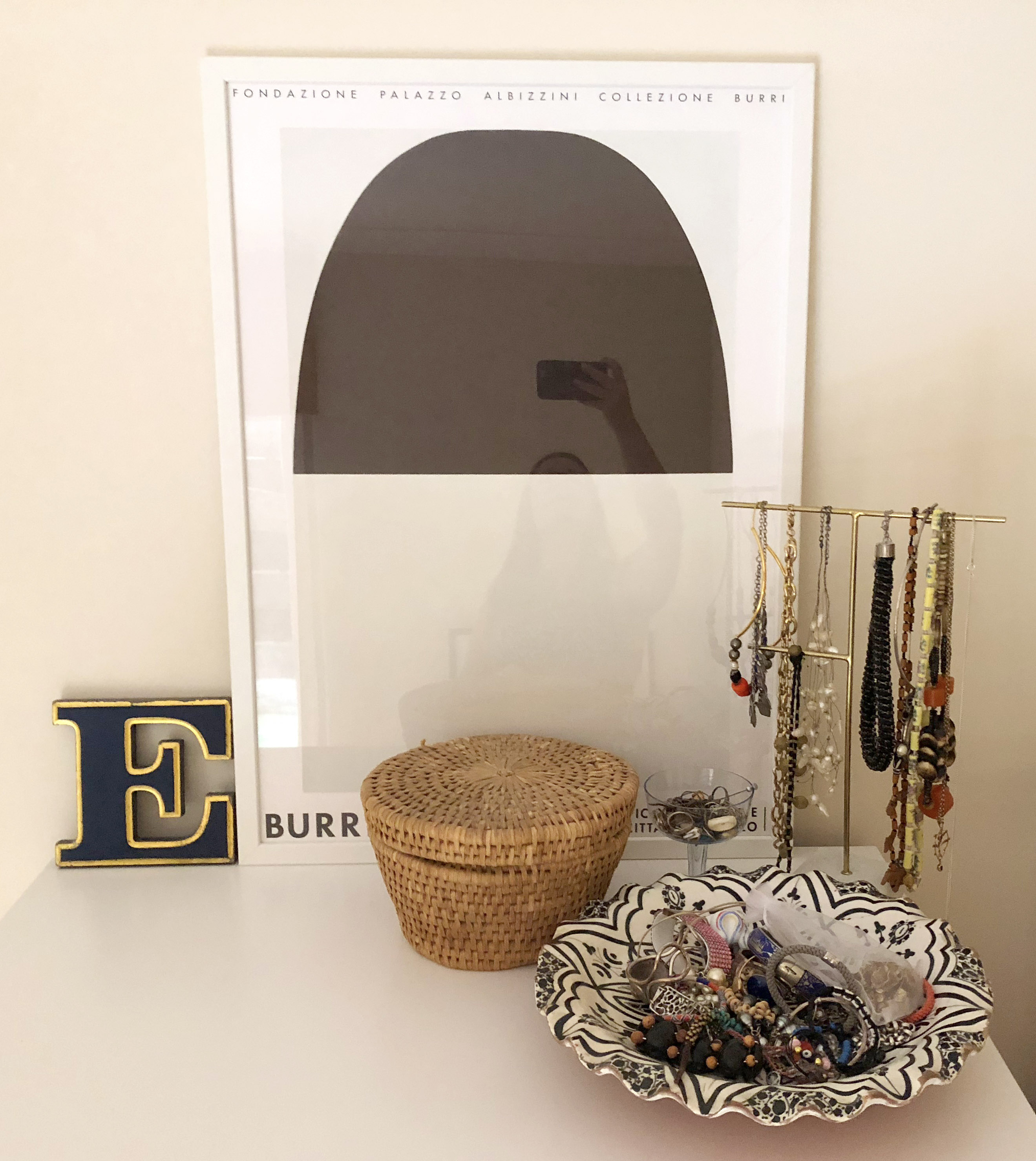Burri poster in bedroom with wooden letter E and jewellery