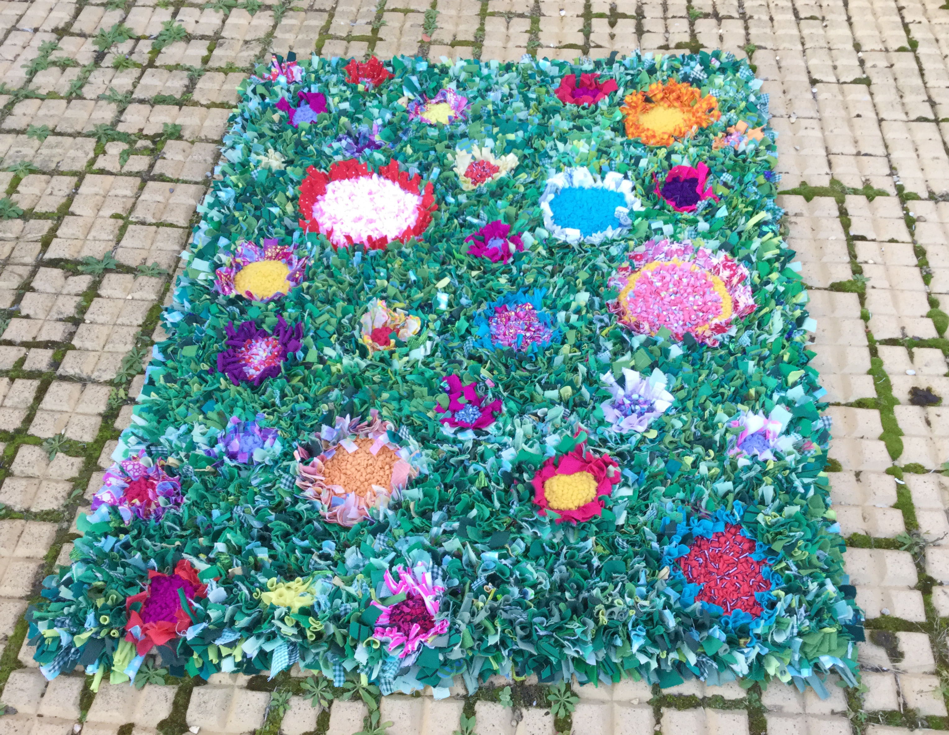 Story time kids rag rug made to look like grass with flowers all over