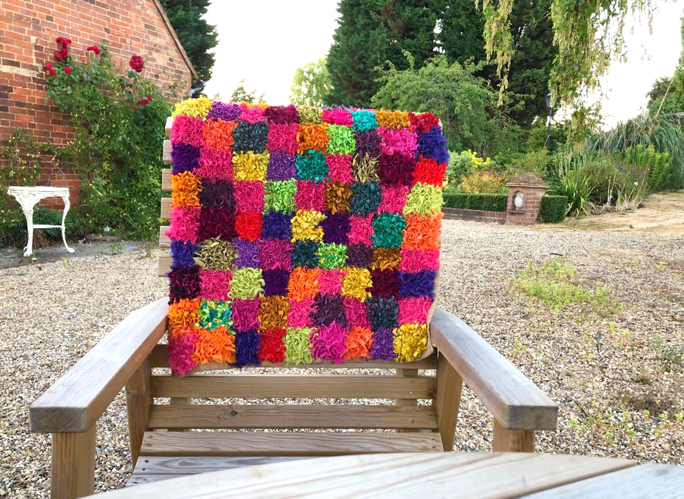 Rag rug on chair in garden in checked design with squares