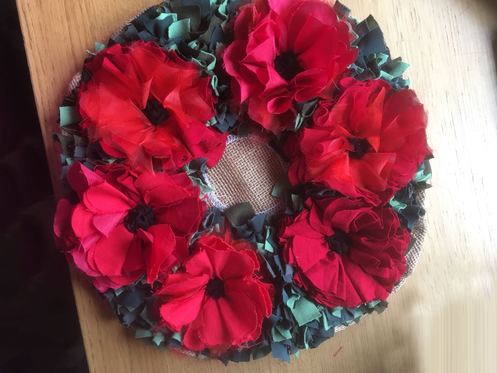 rag rug poppy wreath in red and green made using recycled fabrics