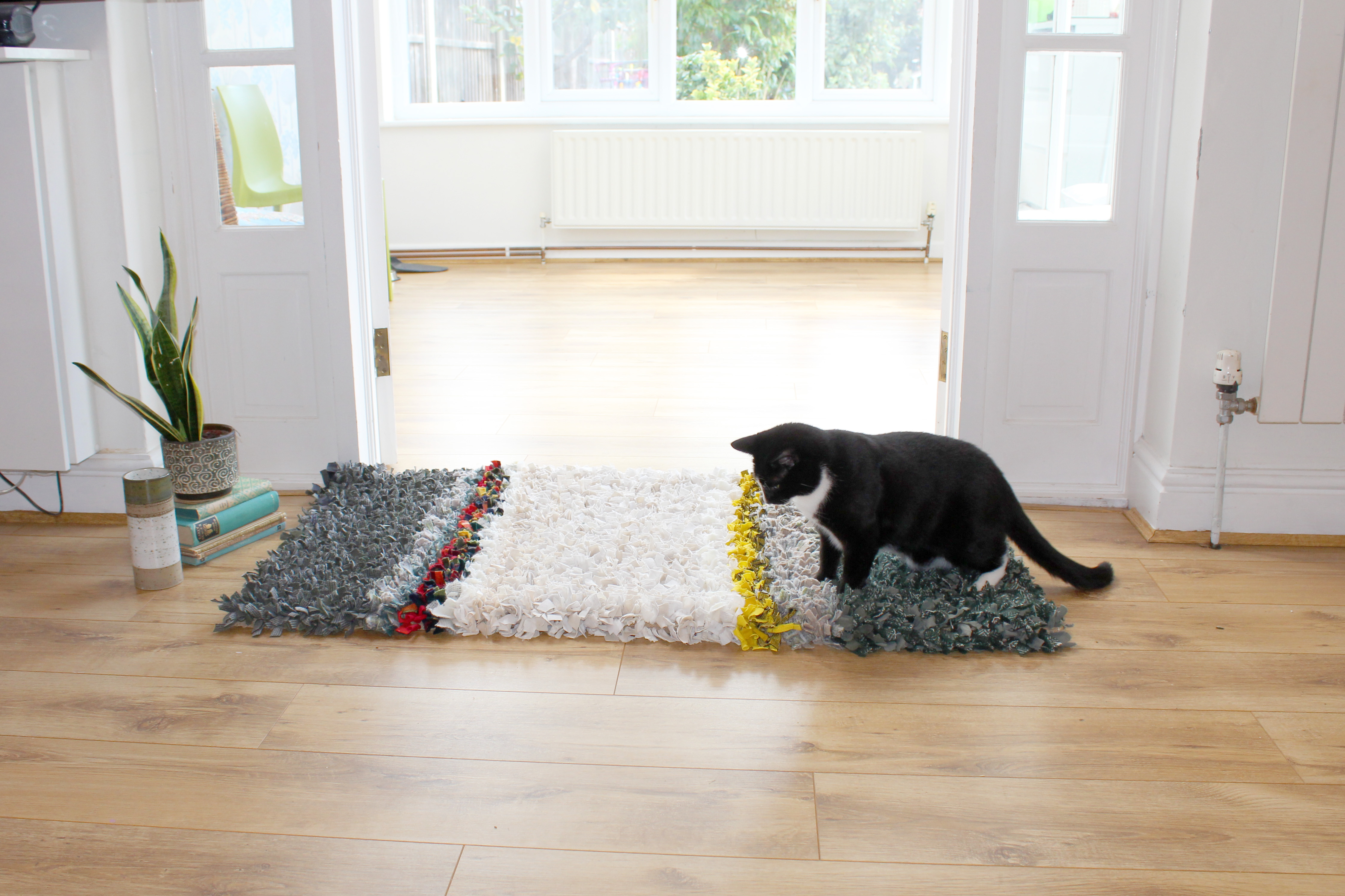 Striped handmade rag rug with cat sitting on it