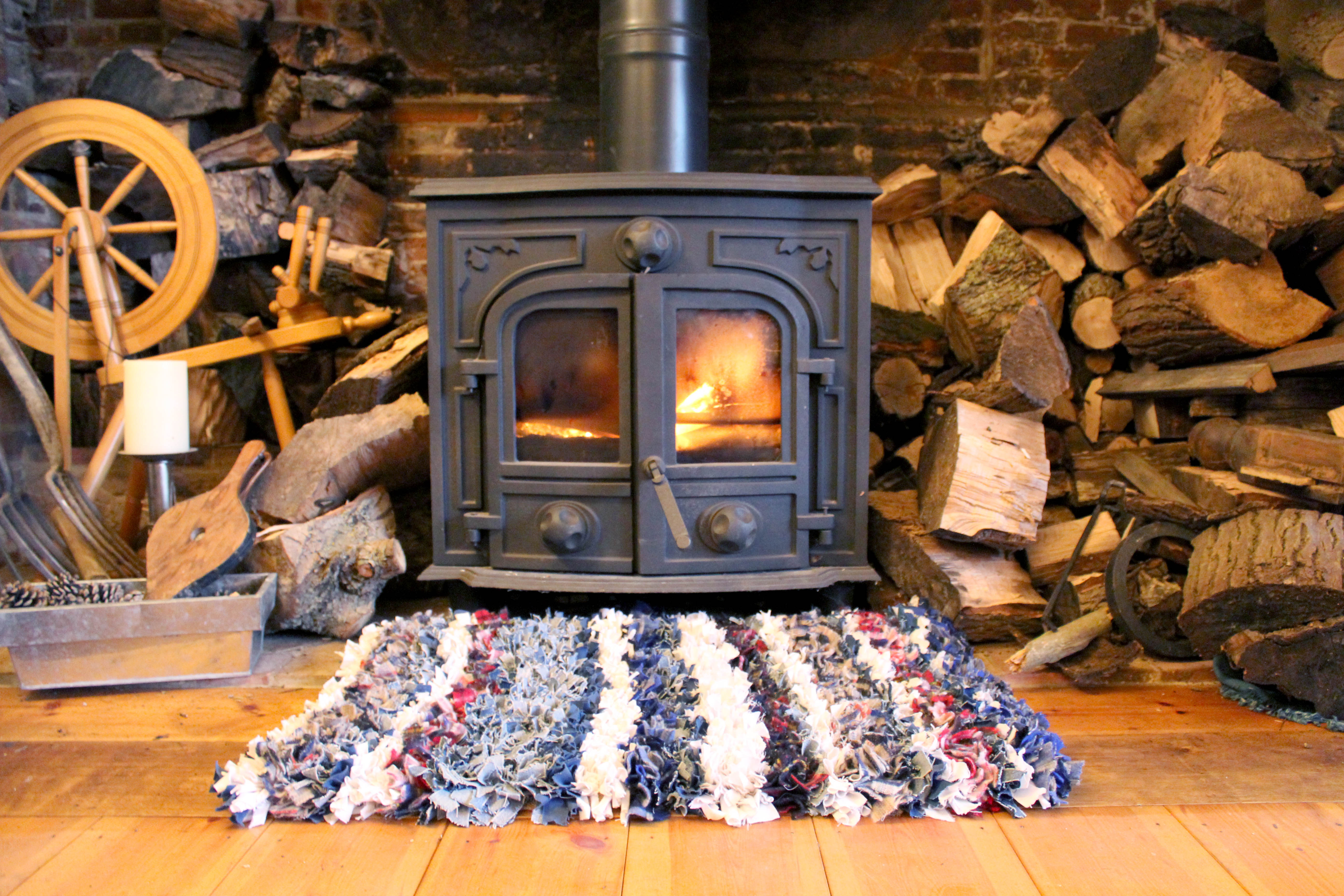log burning stove with striped cosy rag rug with live fire