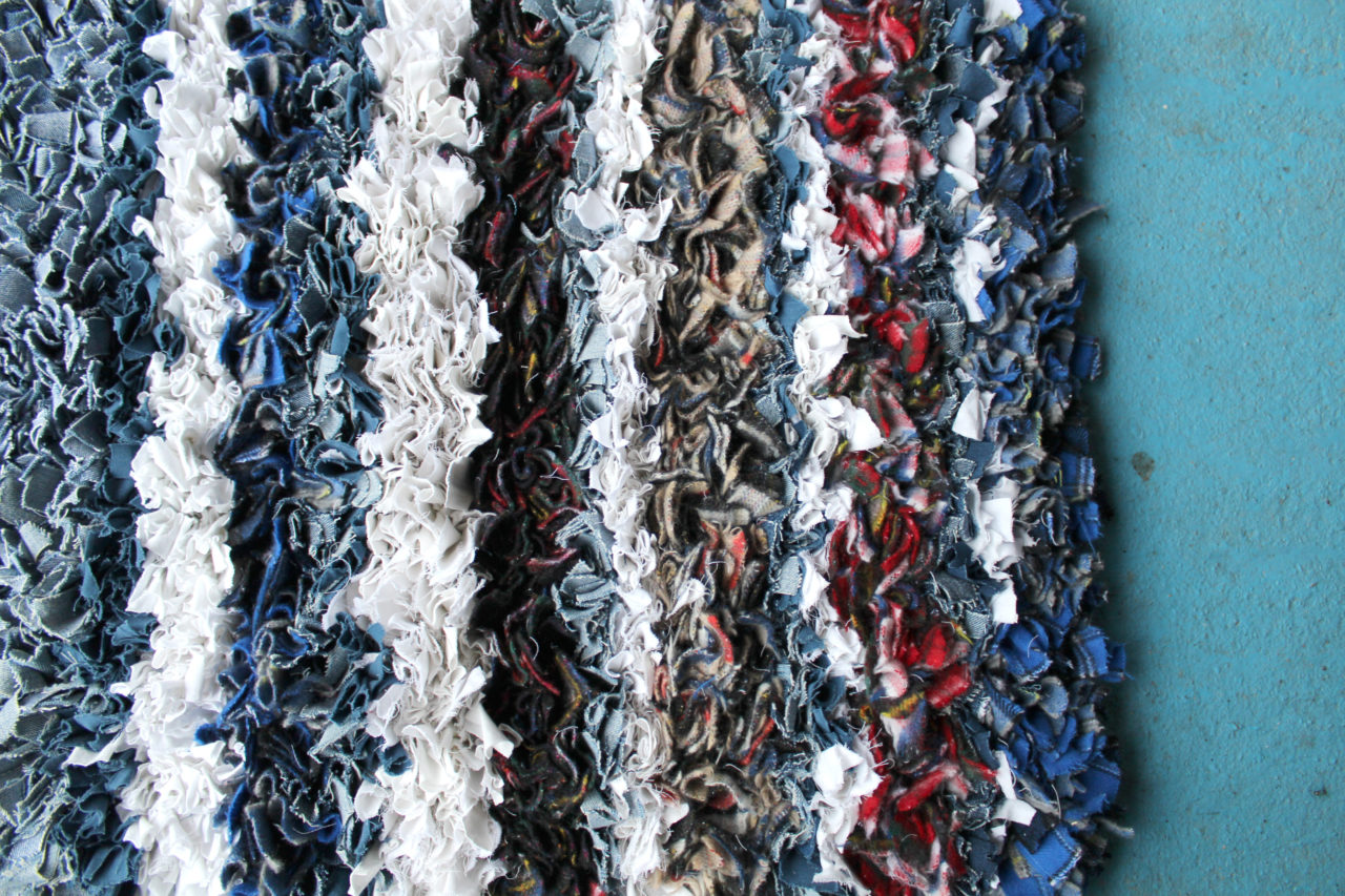 Stripes of white, grey, blue and red fabric for rag rugs