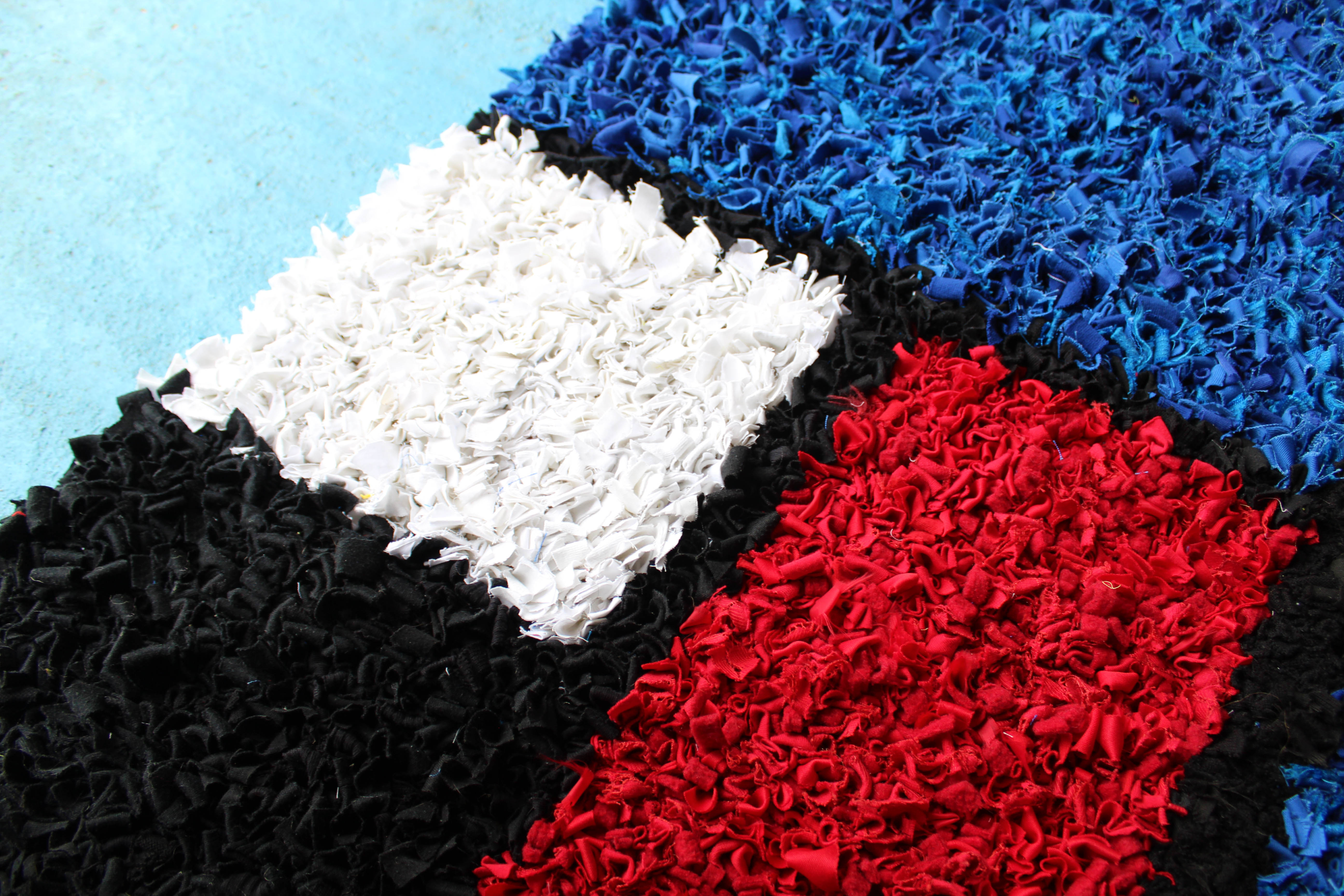 Section of our Mondrian inspired rag rug. Blue, red, white and black blocks of colour woven together in the short shaggy technique of rag rugging. 
