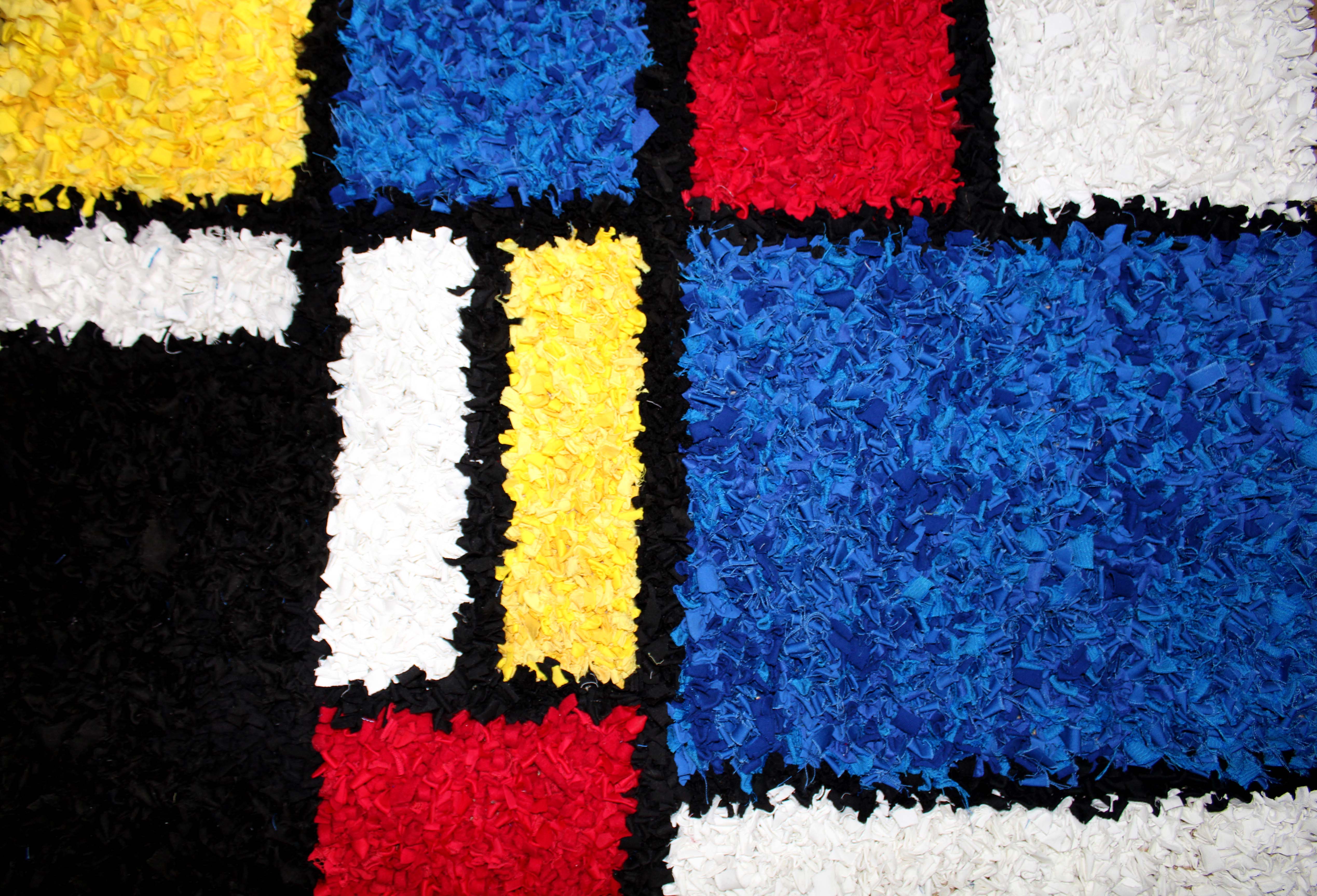 Top down photo of Mondrian inspired rag rug made using old clothing and offcuts from craft projects