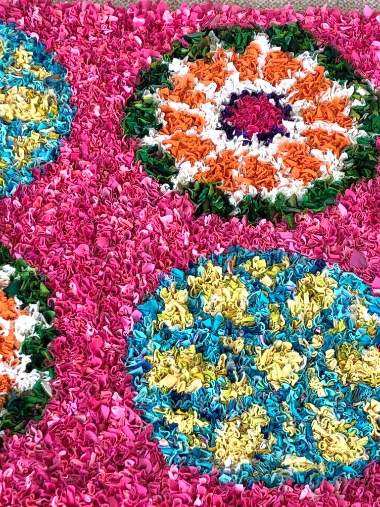 Detail of pink, blue, yellow, green and orange soft homemade rag rug