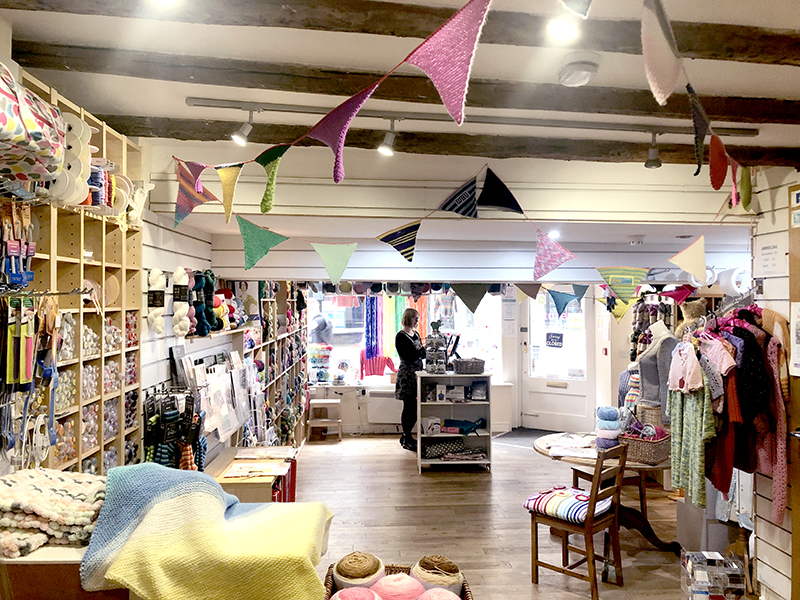 The inside of Knit & Stitch craft shop in York with knitted bunting and rag rug workshops