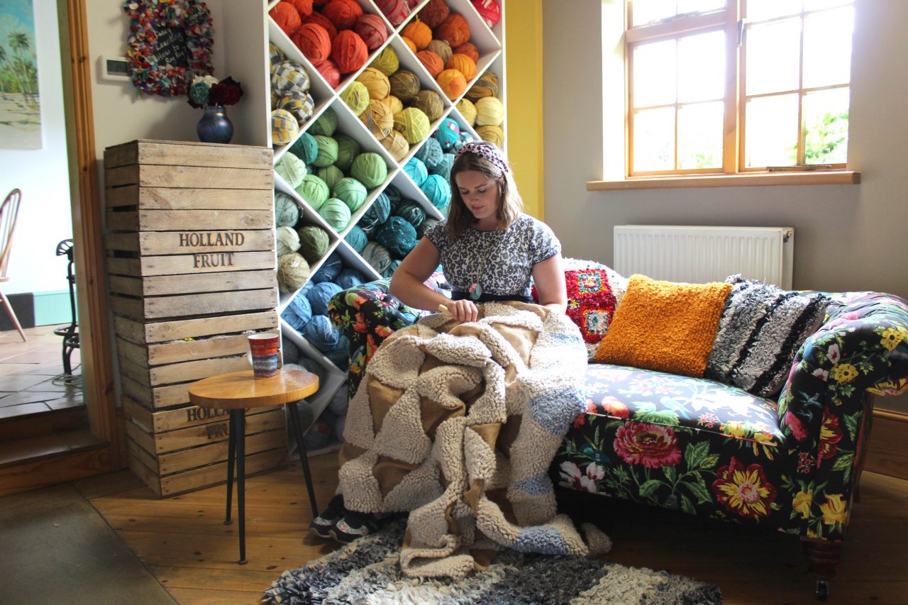 Elspeth Jackson from Ragged Life making a rag rug on a sofa