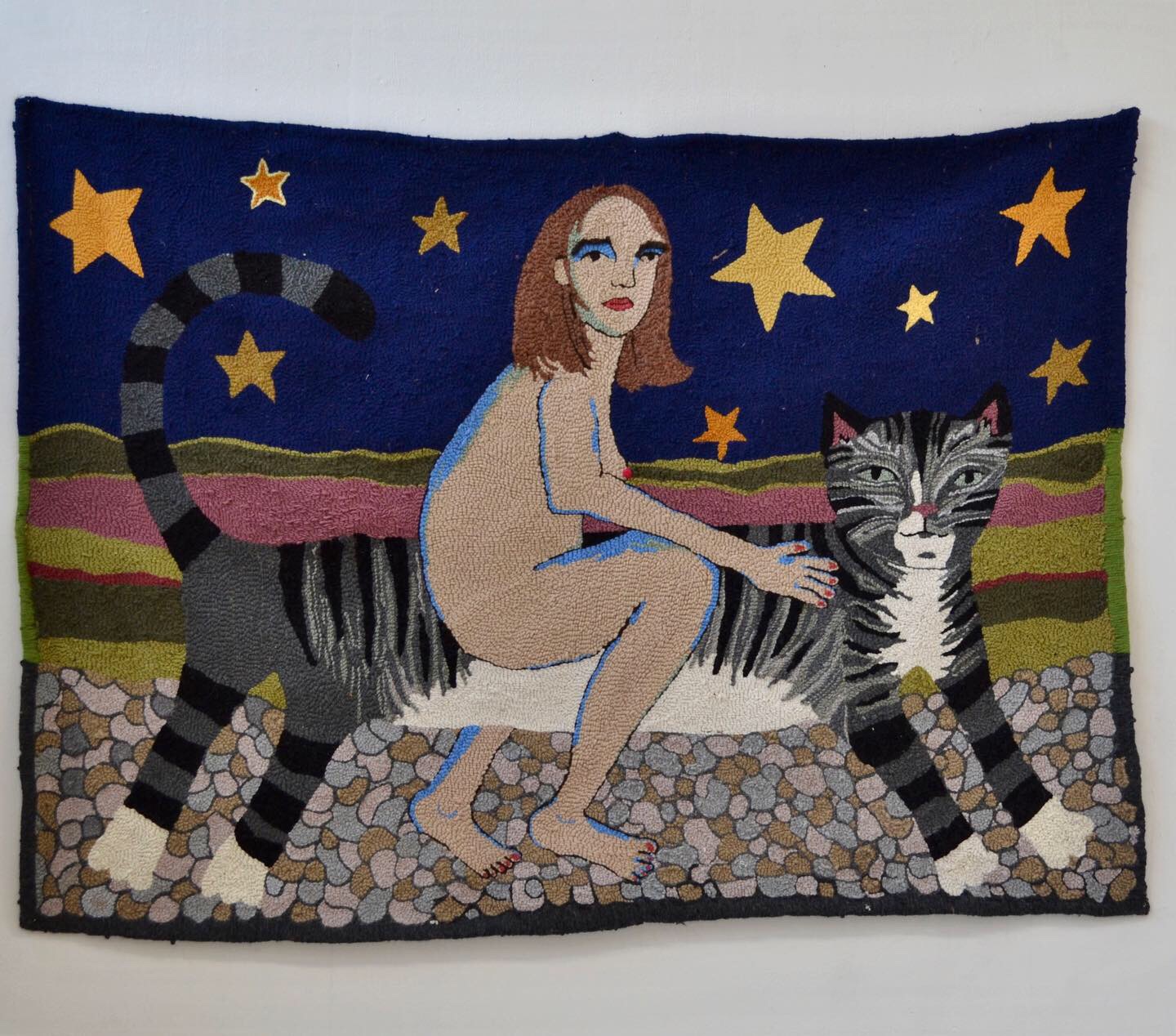 Textile art by Selby Hurst Inglefield of a naked woman riding a cat featuring a blue sky and gold star background