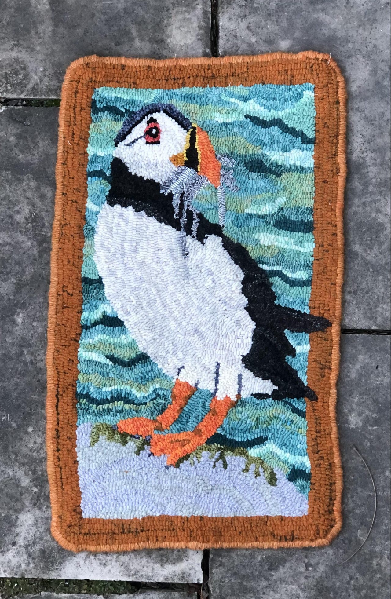 hooked rug art of a puffin with fish in its mouth by Yvonne Iten-Scott
