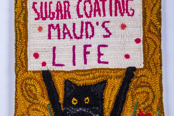textile art featuring a cat holding a sign that says 'stop sugar coating Maud's life' by Laura Kenney