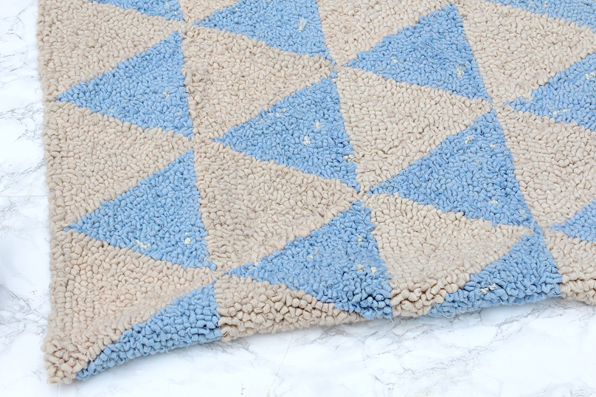 Baby blue and cream rug on marble floor