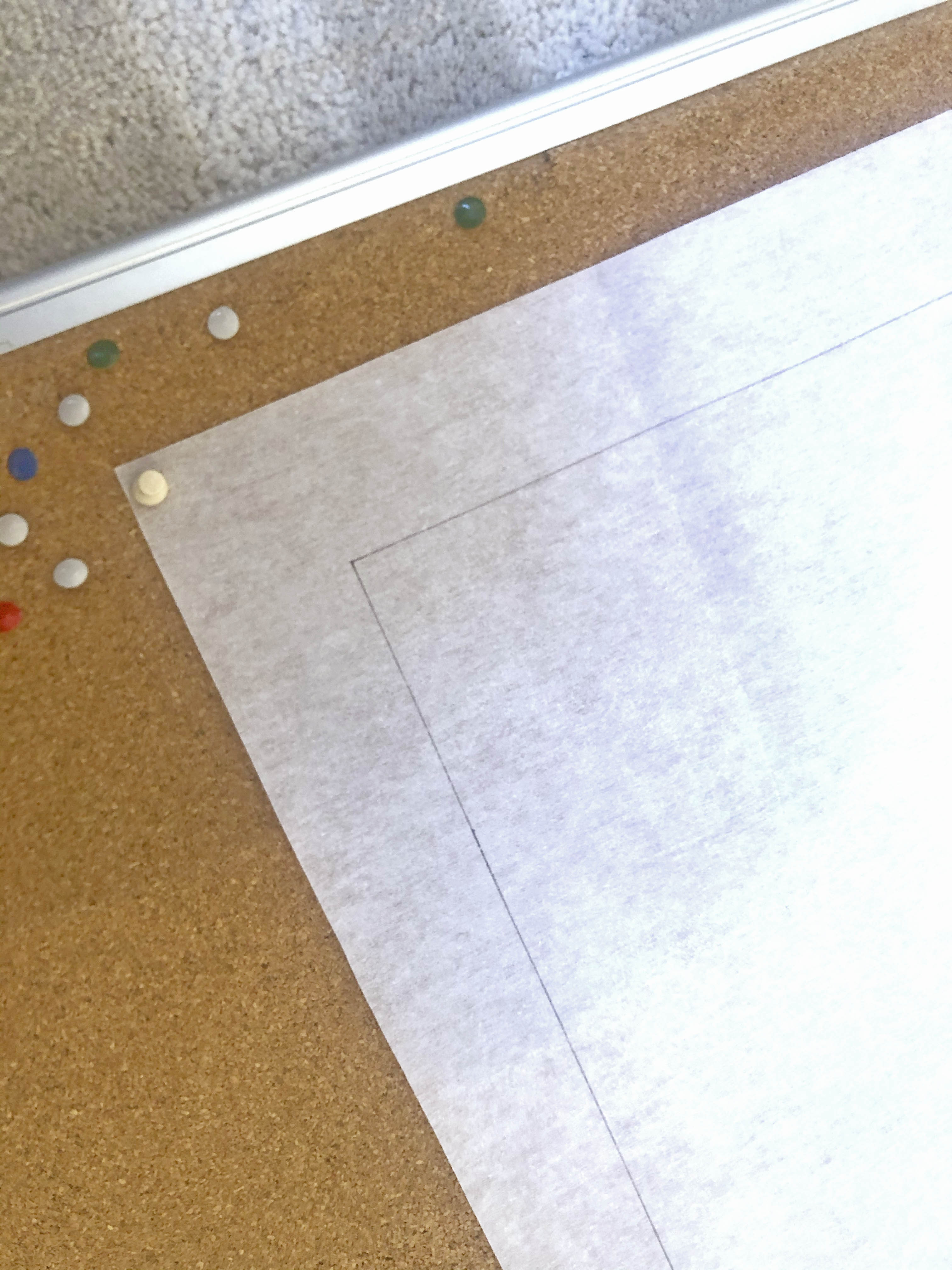 Iron on interfacing pinned to a cork board for crafting