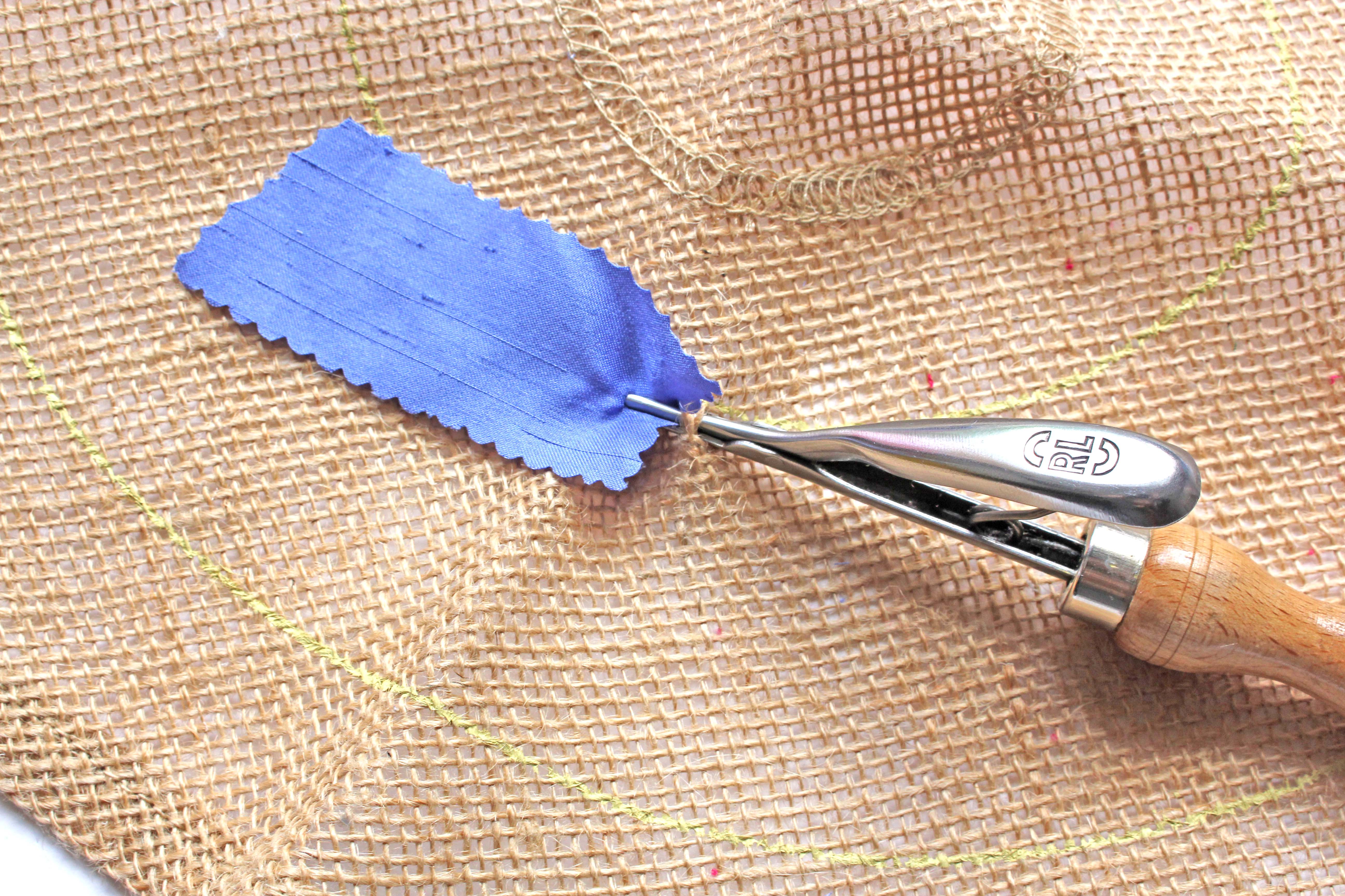 Pulling Purple Fabric Through Hessian with Spring Tool