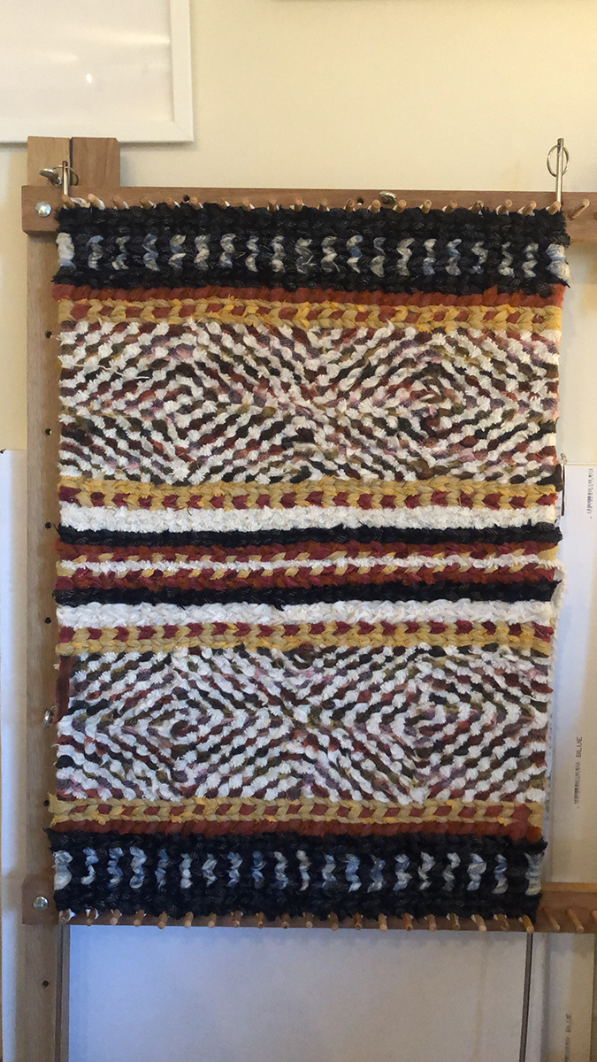 Finished twined rug still on the loom