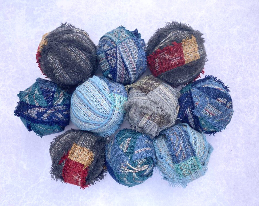 Group shot of blue and grey balls of chenille offcuts from the Yorkshire mills