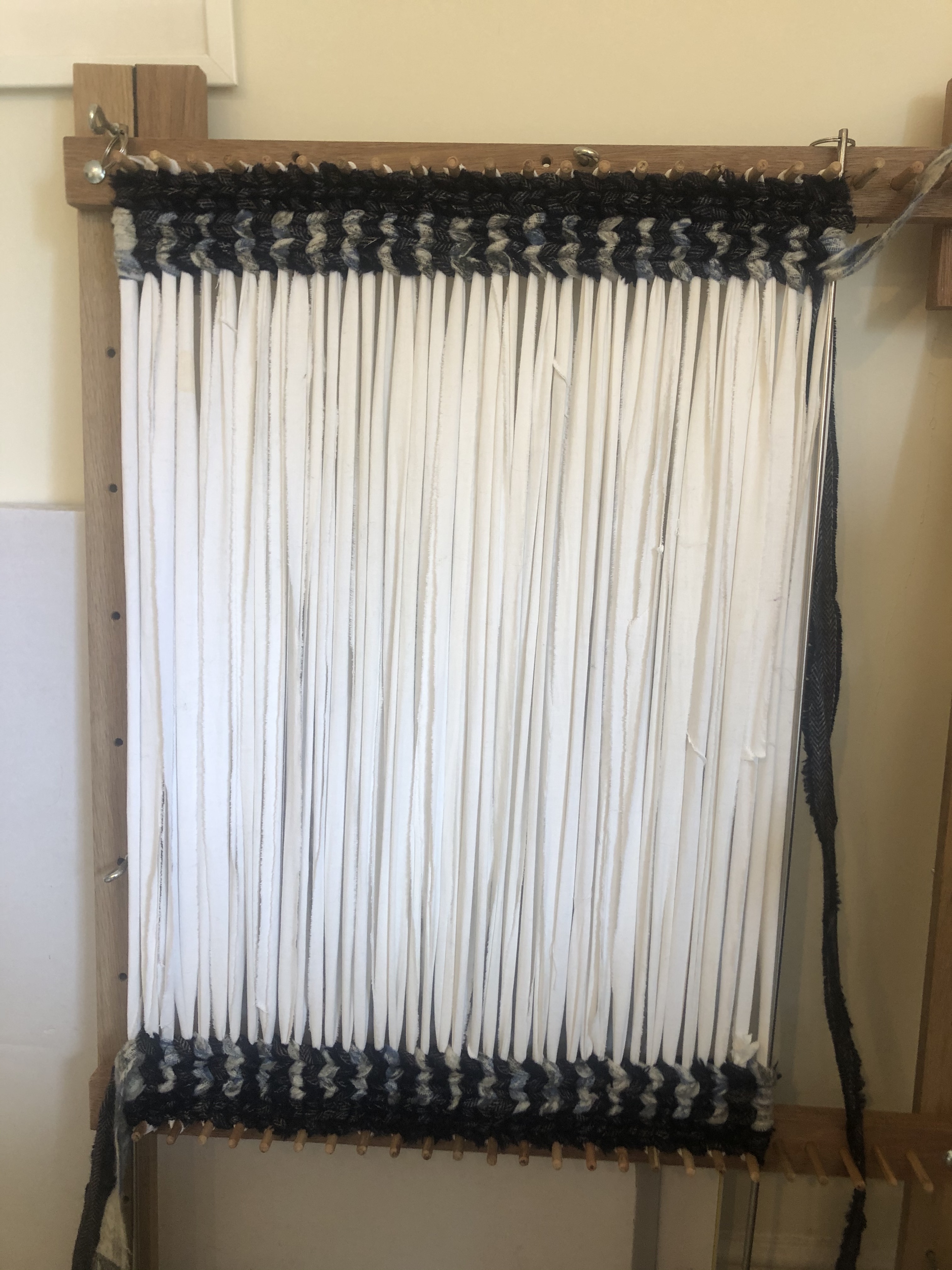 Twining from the top and bottom of the wooden loom with cotton fabric warp