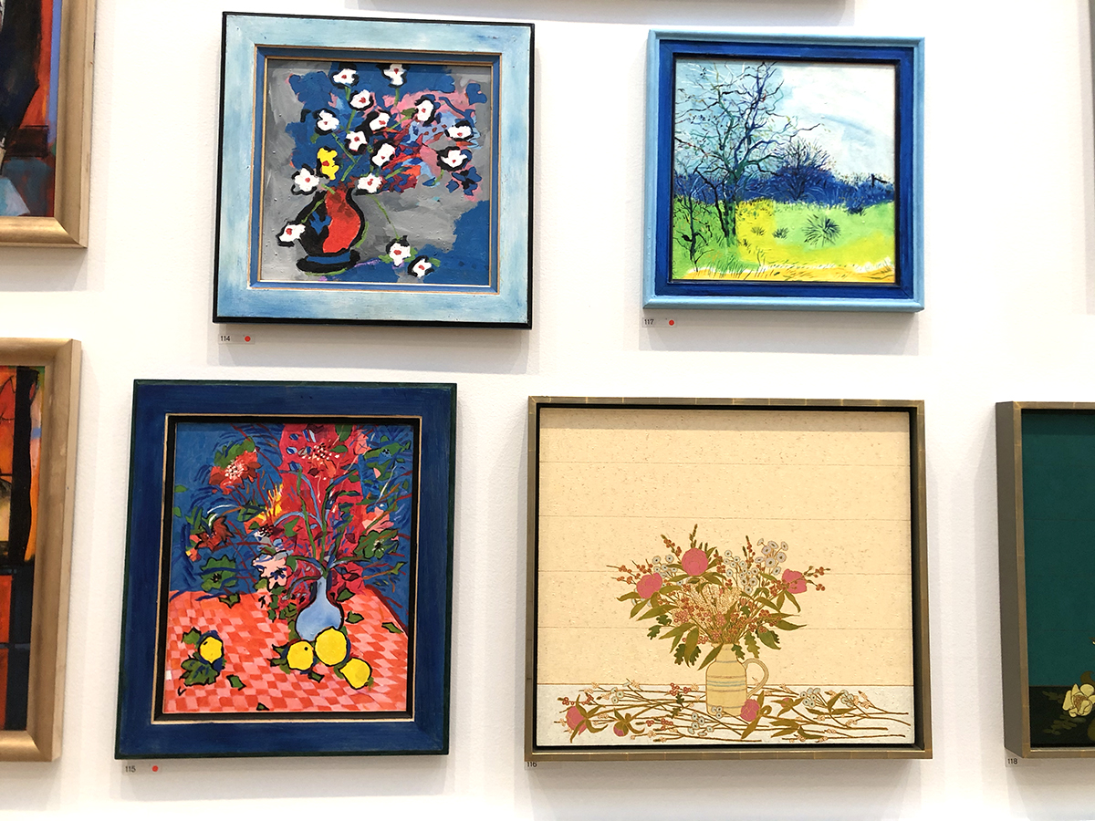 photograph of royal academy exhibition wall display colourful framed paintings flowers and tree