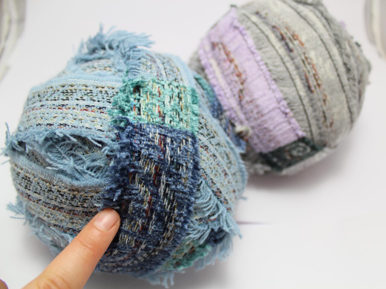 Balls of chenille yarn with stitching. Strips for rag rugging.