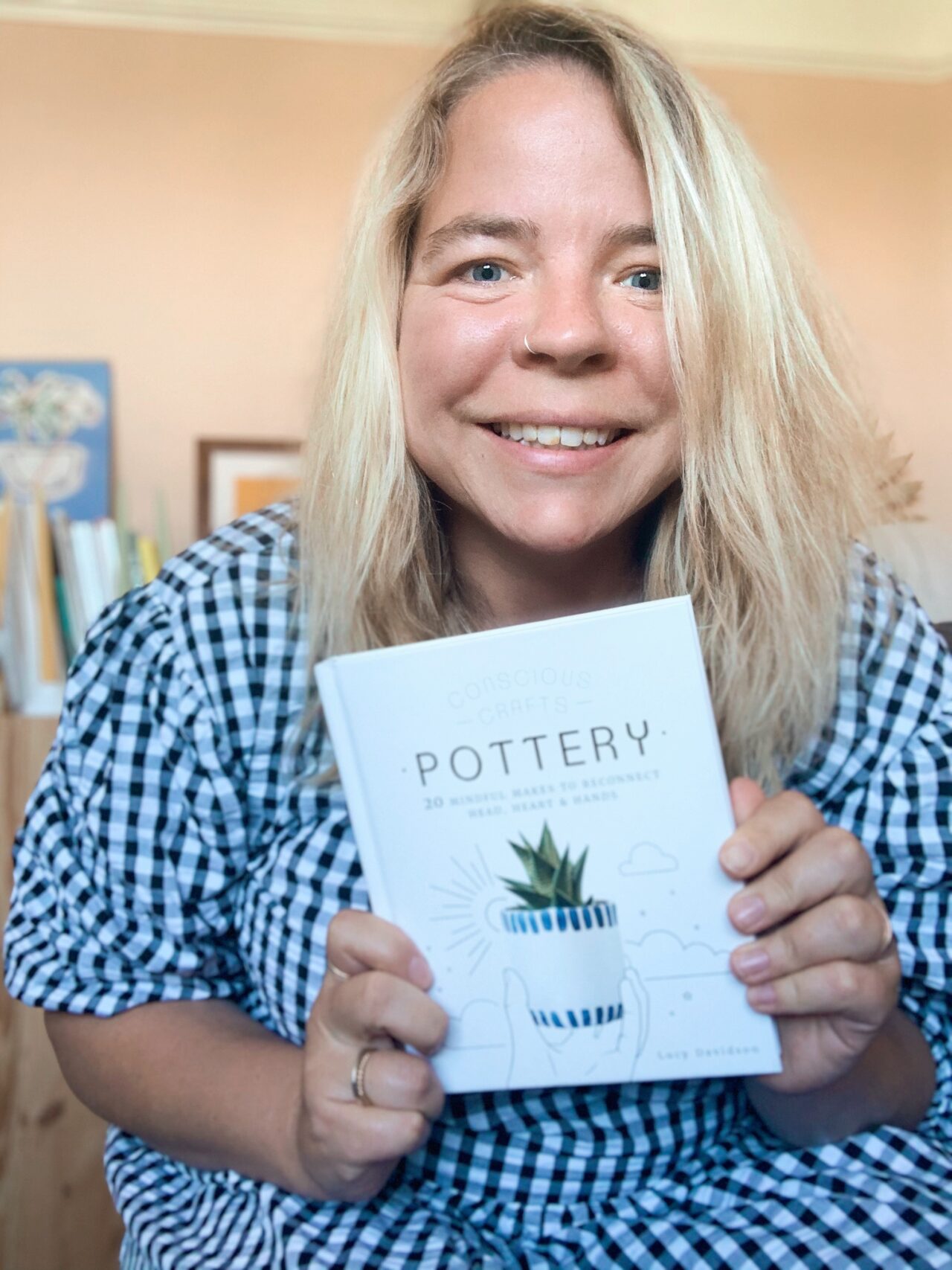Lucy Rowan holding her book on pottery