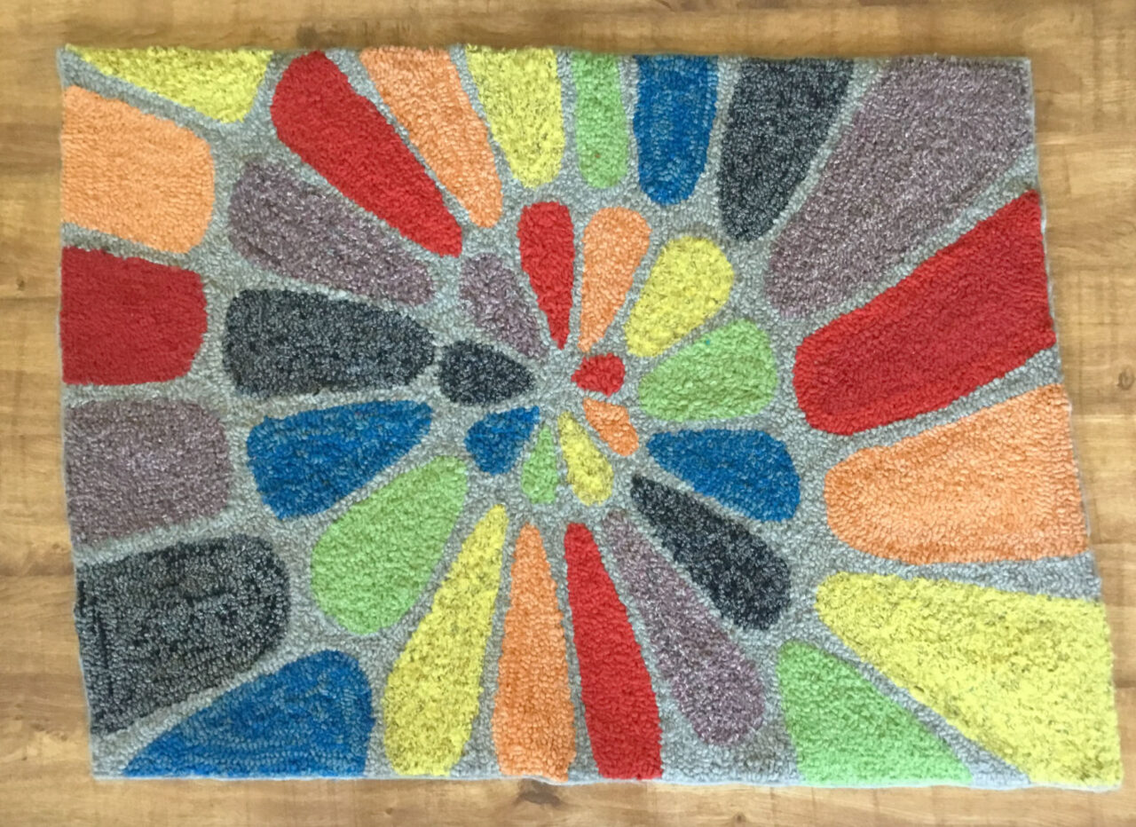 Rainbow coloured spiral design rag rug on Ragged Life pre-printed rag rug hessian